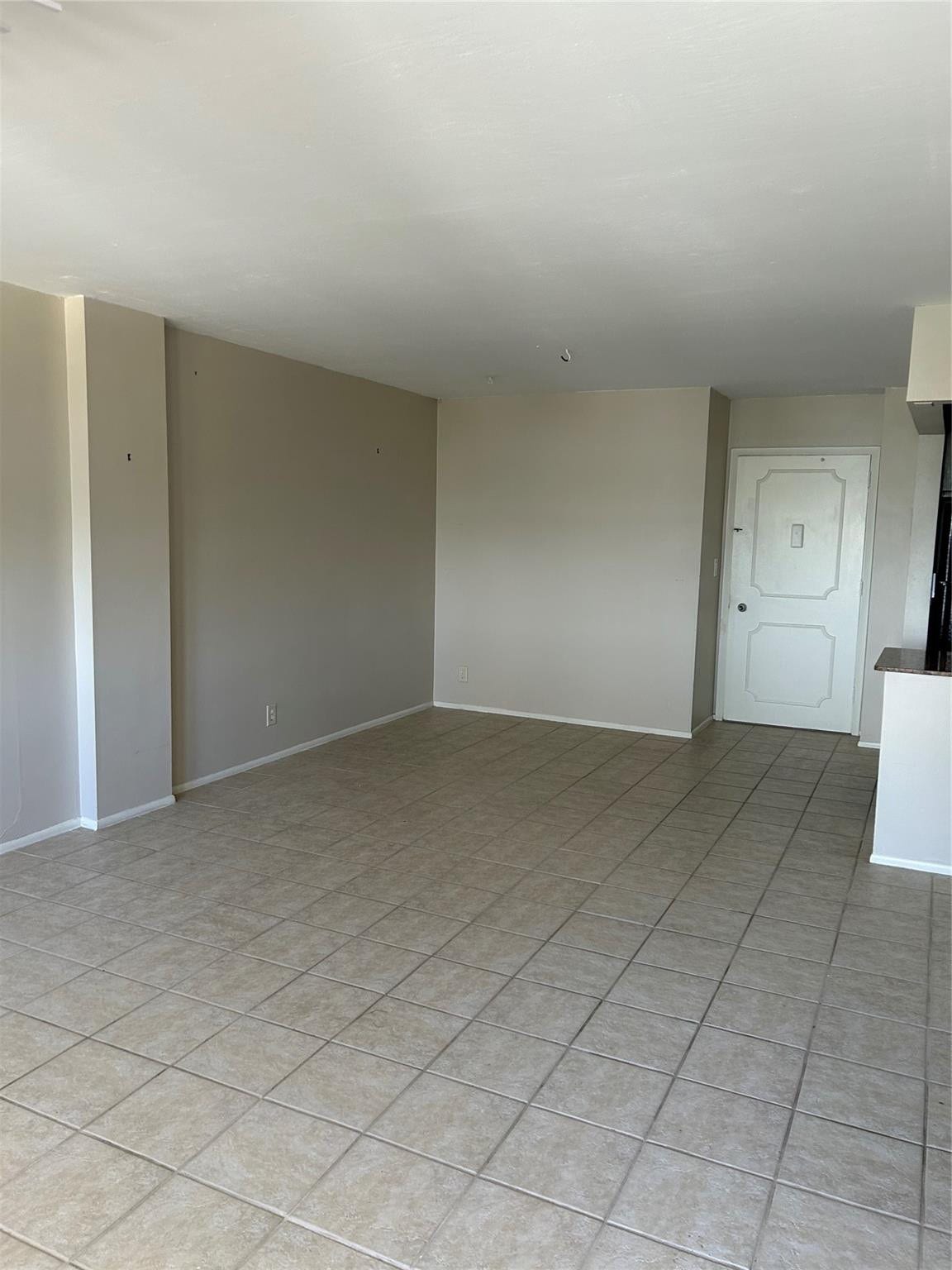 305 N POMPANO BEACH Boulevard, #206, Pompano Beach, Pompano Beach, FL 33062 Open interior area featuring neutral wall paint, large-format ceramic tile flooring, and a paneled entry door