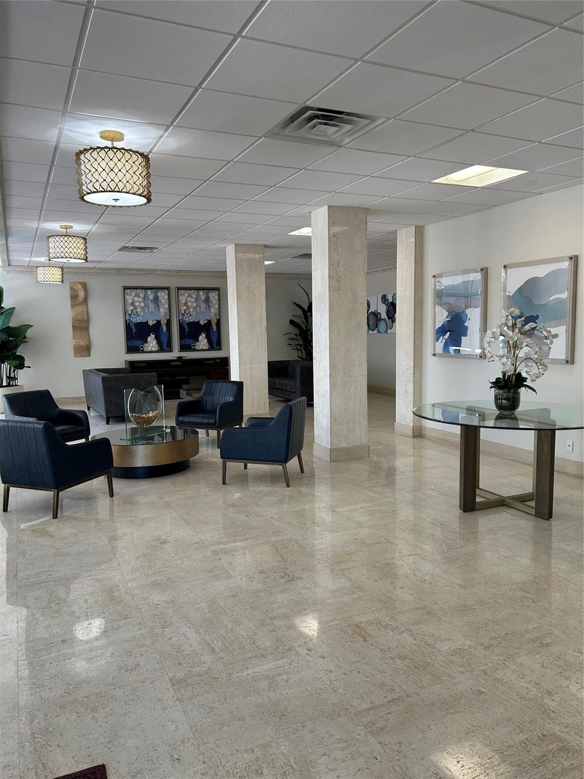 305 N POMPANO BEACH Boulevard, #206, Pompano Beach, Pompano Beach, FL 33062 Polished stone flooring, structural columns with stone-finish cladding, and drum-style decorative lighting