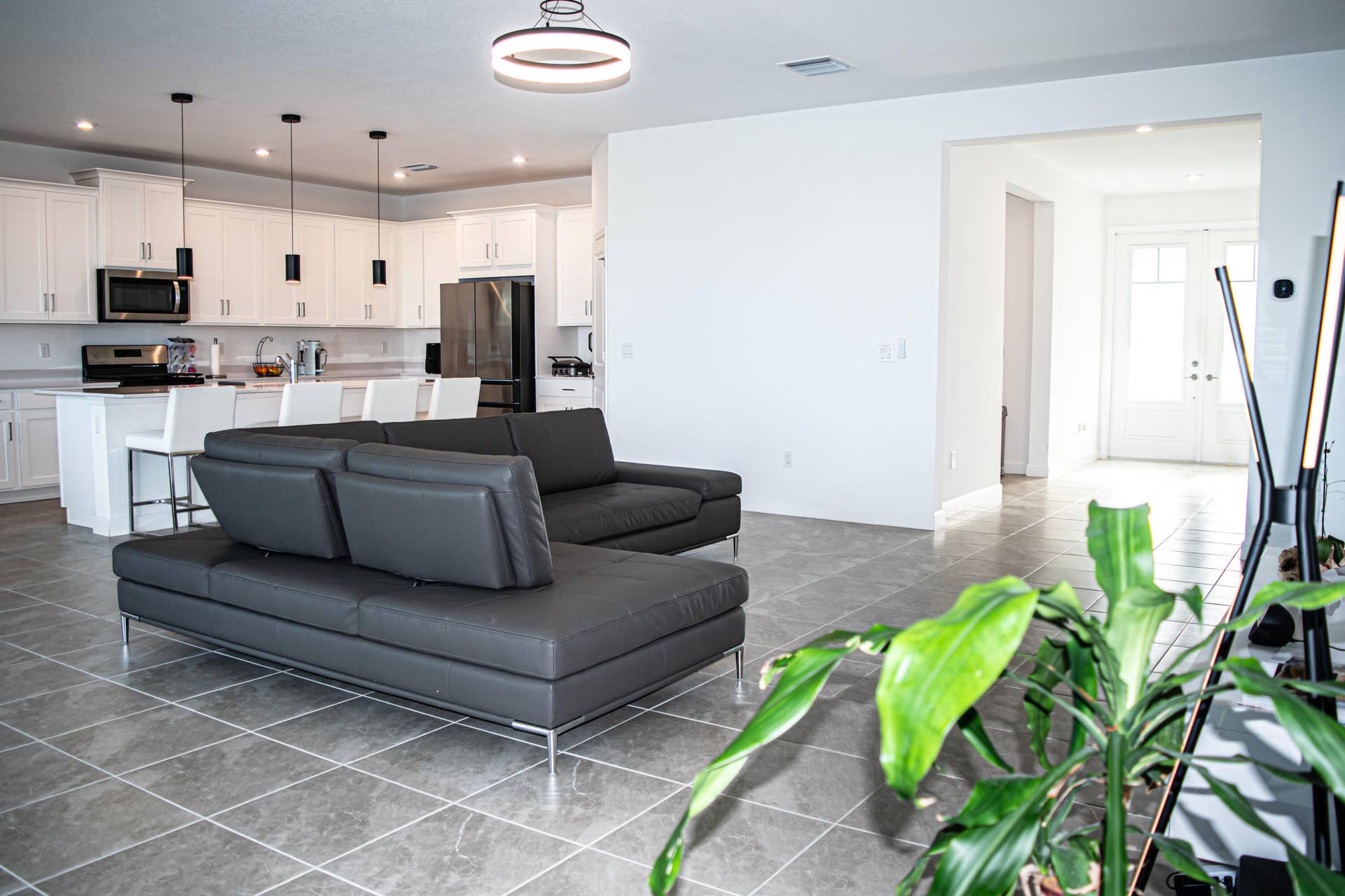 10317 SW Phineas Lane, Port St Lucie, FL 34987 Open-concept kitchen featuring white shaker-style cabinetry, quartz countertops, a kitchen island, recessed lighting, and large-format tile flooring