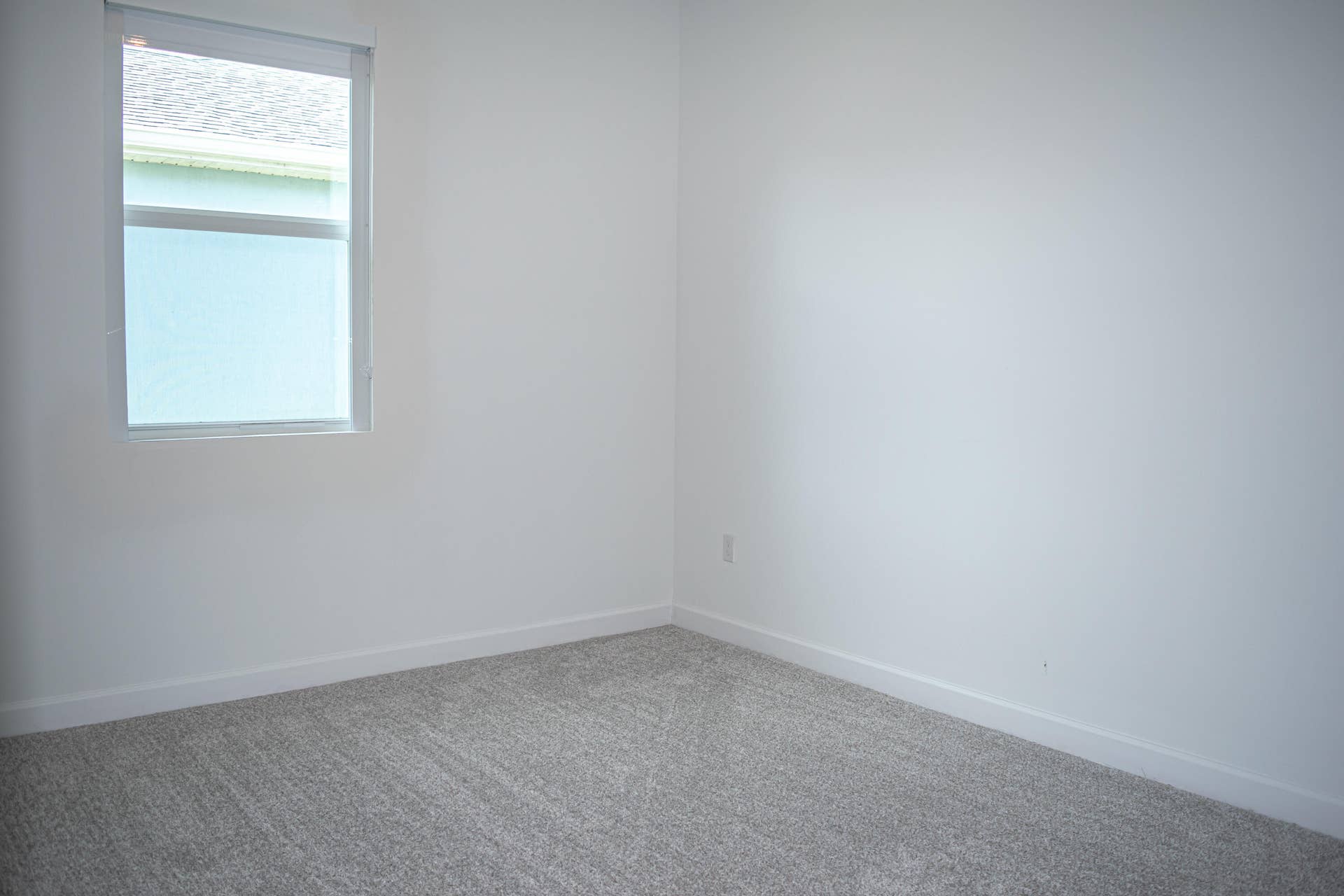 10317 SW Phineas Lane, Port St Lucie, FL 34987 Neutral interior room featuring neutral-toned carpeting and a window with a fitted roller shade