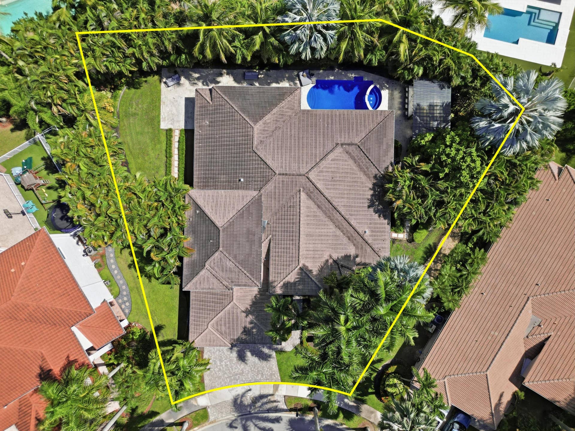 1580 VICTORIA ISLE Way, Weston, FL 33327 Aerial view of property featuring a hip roof, swimming pool with integrated spa, stone-paver driveway, and manicured landscaping