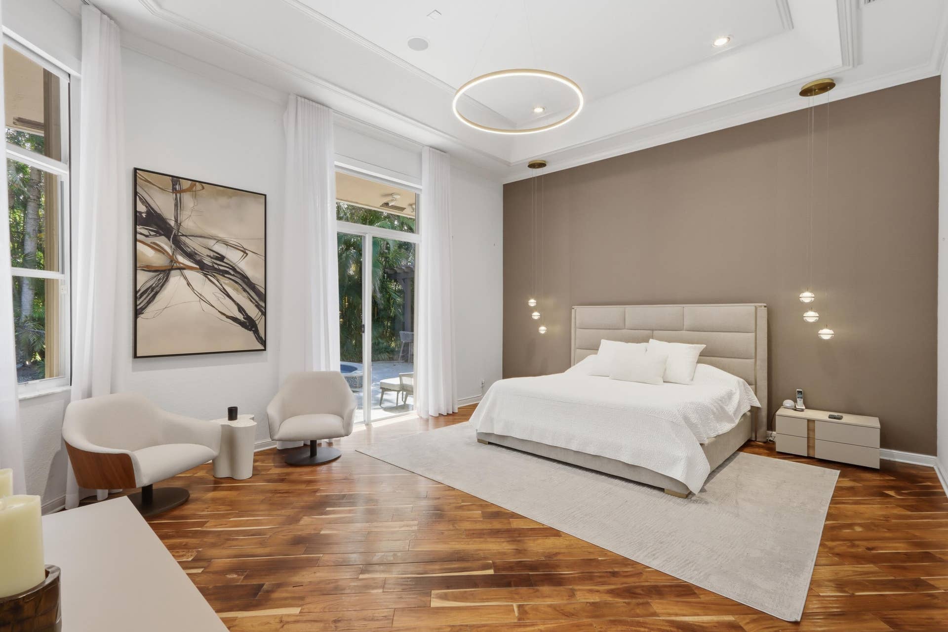 1580 VICTORIA ISLE Way, Weston, FL 33327 Tray ceiling with recessed lighting, wood-finish flooring, circular pendant chandelier, accent wall, and floor-to-ceiling glass patio doors