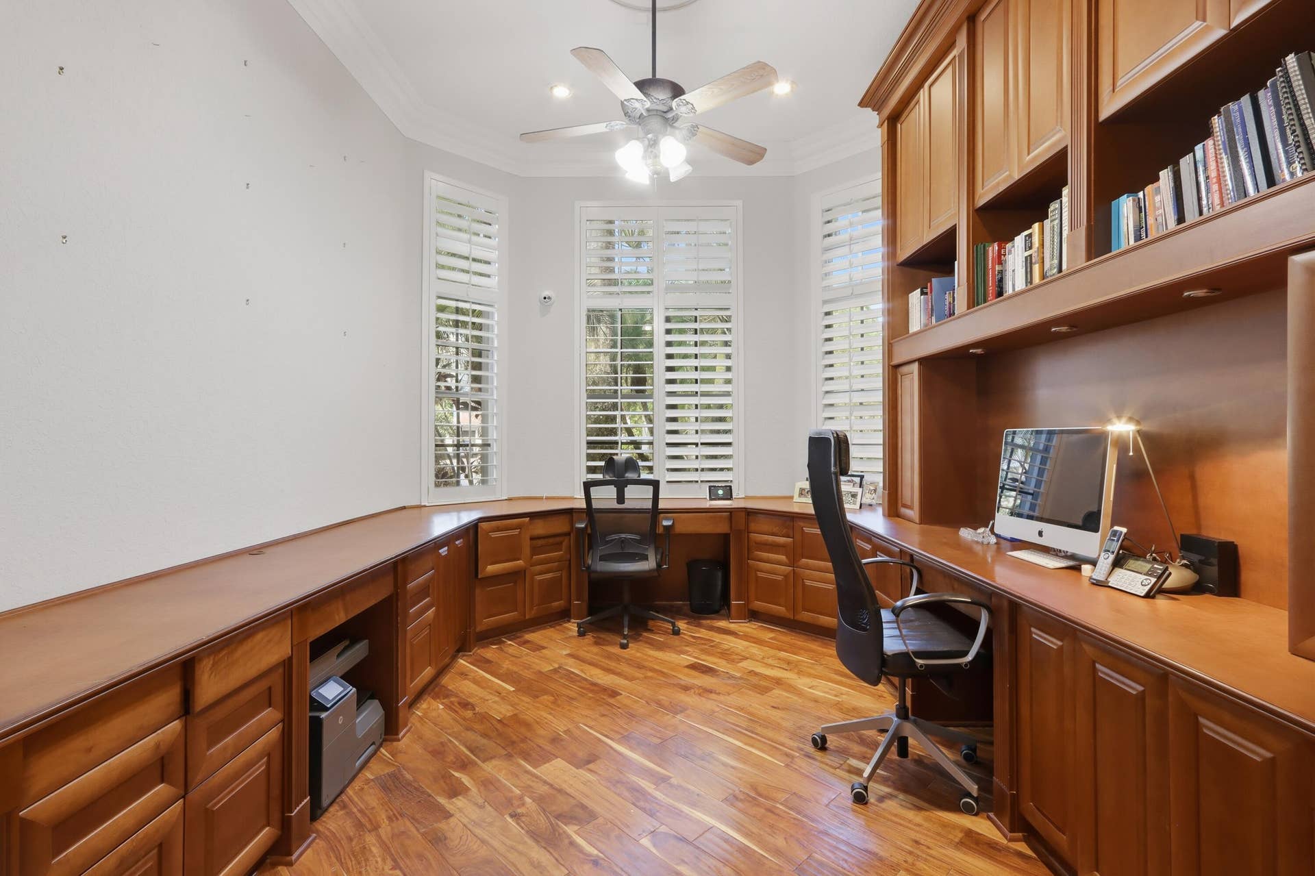 1580 VICTORIA ISLE Way, Weston, FL 33327 Custom built-in wood cabinetry, integrated desk workspace, bay windows with plantation shutters, wood-finish flooring, and crown molding