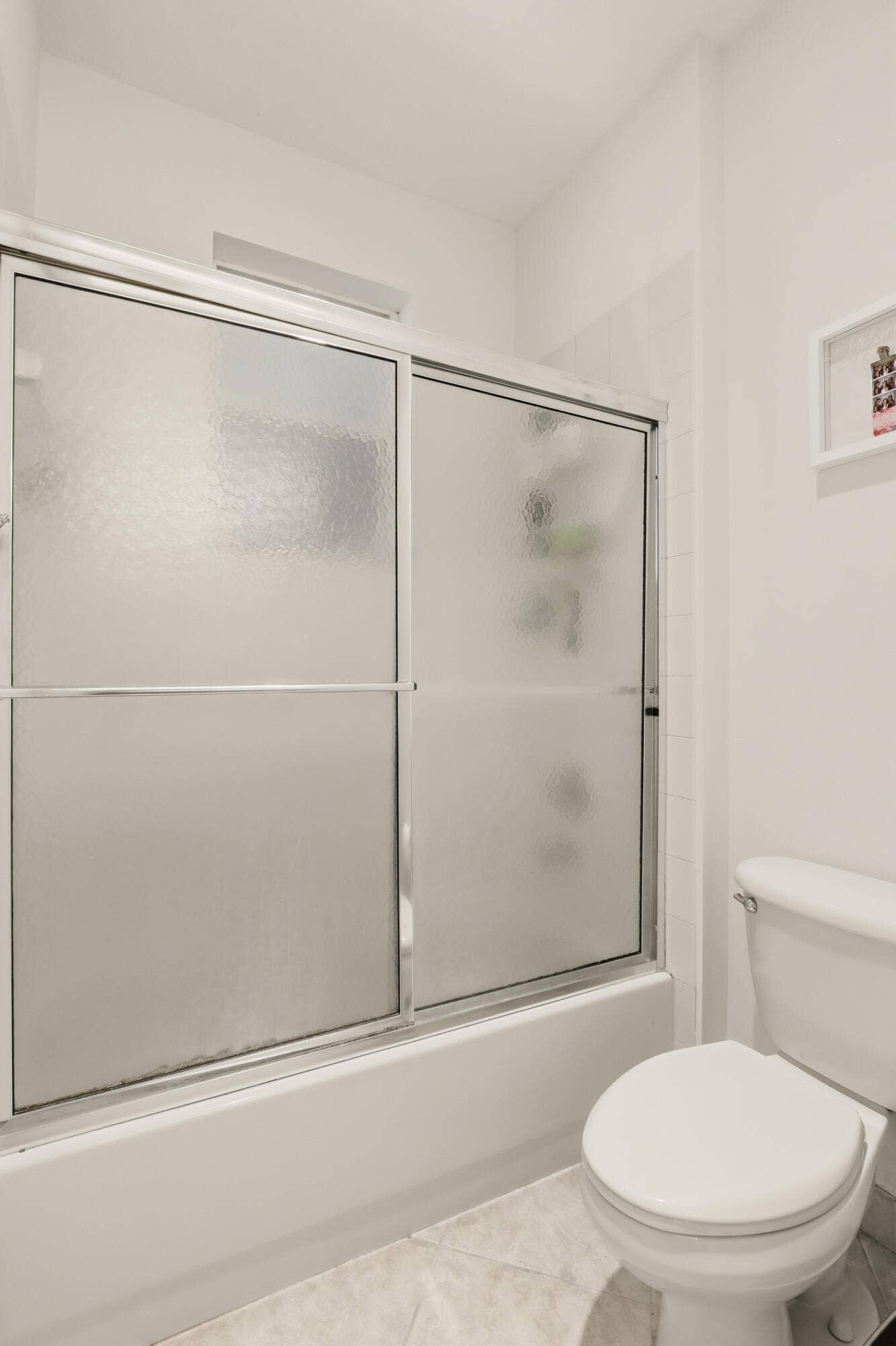 1580 VICTORIA ISLE Way, Weston, FL 33327 Shower enclosure with chrome-finished sliding glass doors, and a standard-height porcelain toilet
