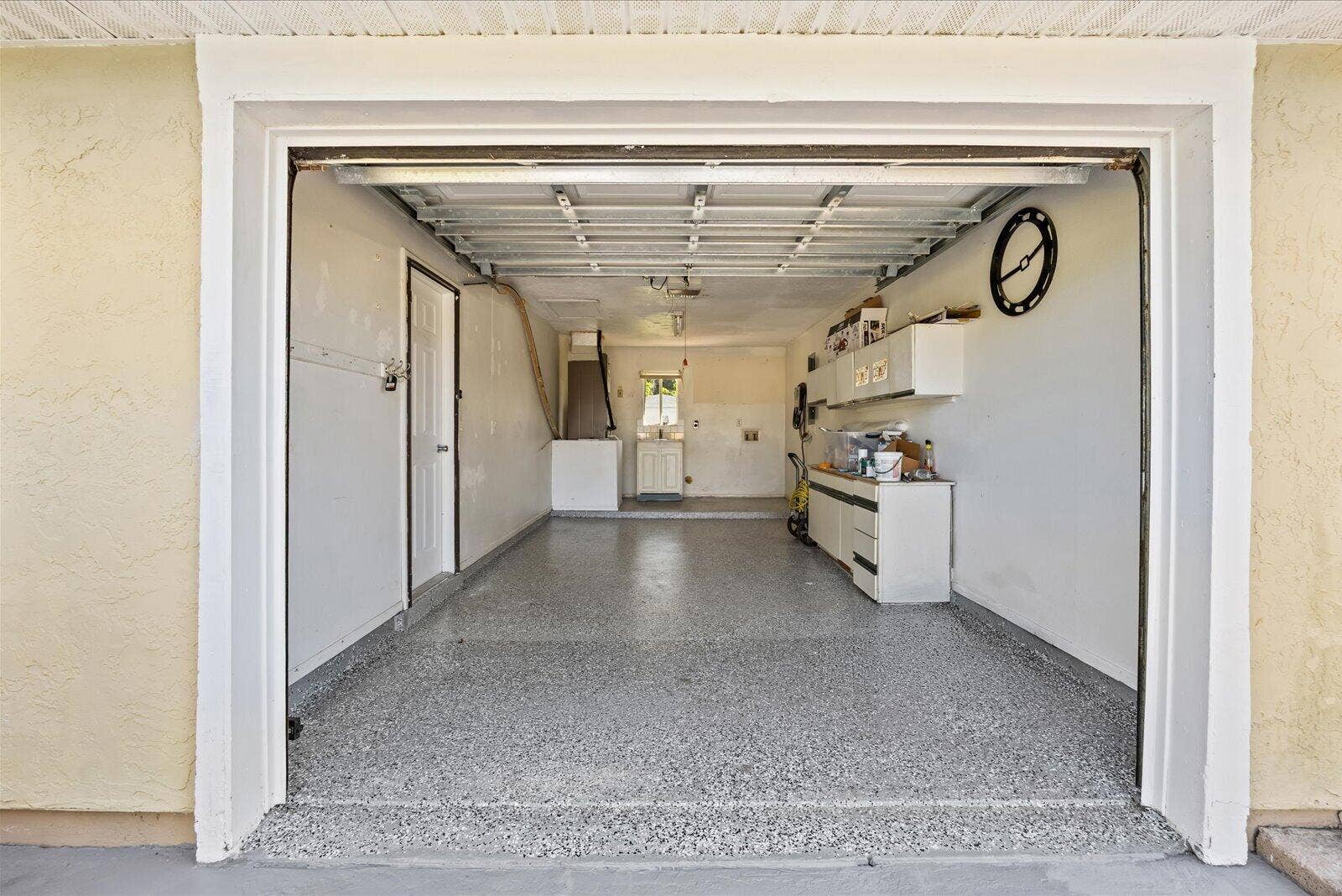 113 CONOVER Avenue, Sebastian, FL 32958 Enclosed garage featuring durable epoxy-coated flooring, built-in wall cabinetry, and a utility sink