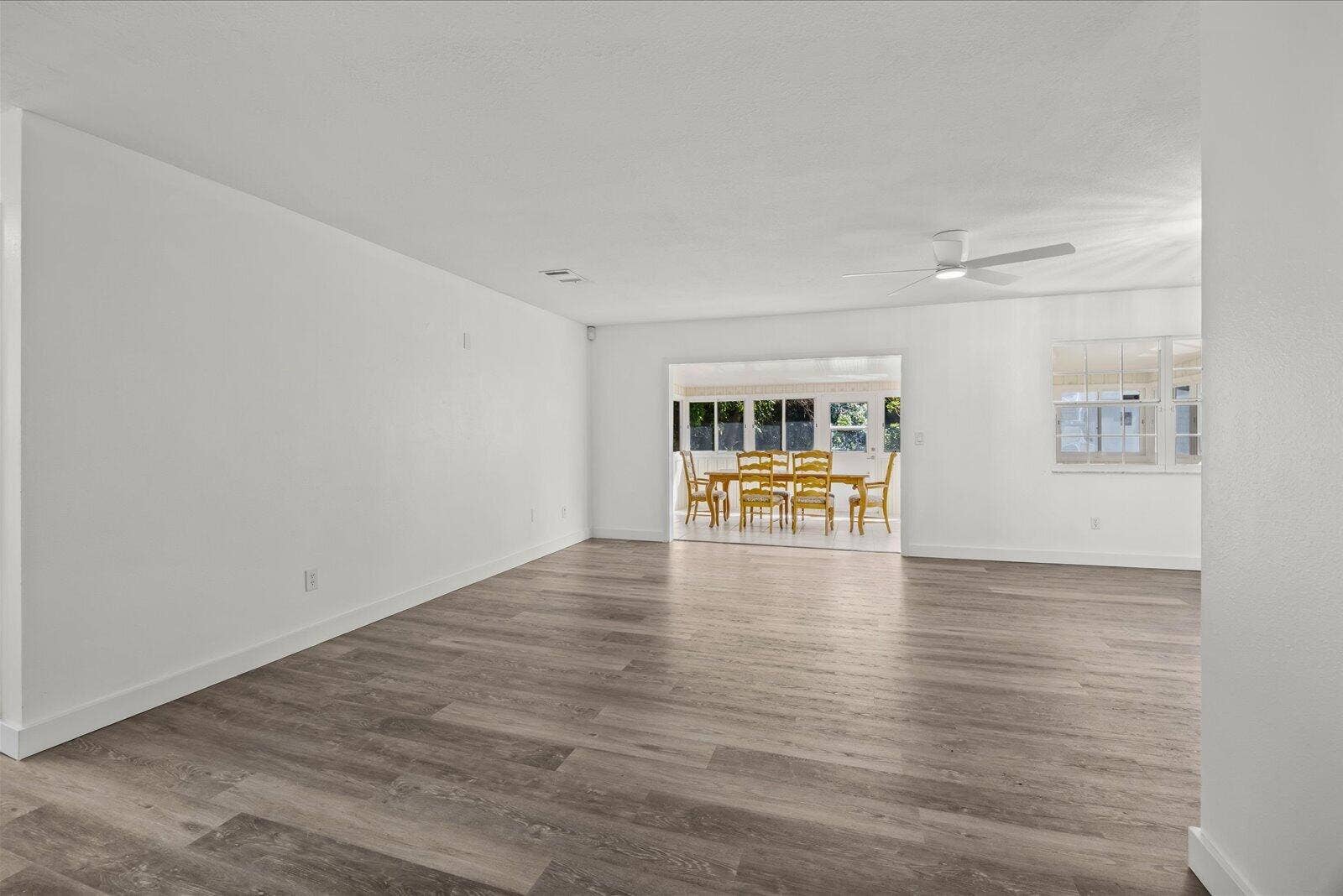 113 CONOVER Avenue, Sebastian, FL 32958 Open floor plan featuring wood-finish flooring, neutral wall tones, multi-pane windows, and a ceiling fan with integrated lighting