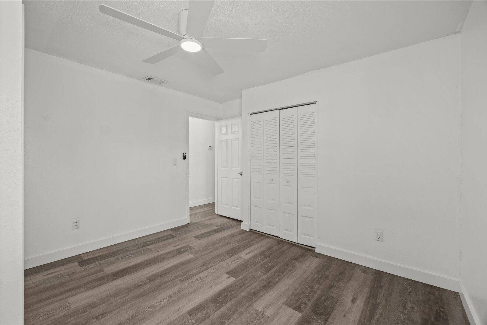 113 CONOVER Avenue, Sebastian, FL 32958 Neutral interior featuring wood-finish flooring, a contemporary ceiling fan with integrated lighting, and a closet with louvered doors
