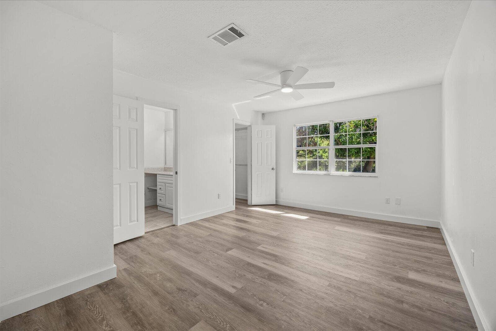 113 CONOVER Avenue, Sebastian, FL 32958 Neutral interior featuring wood-finish flooring, a multi-pane window, and a ceiling-mounted light fixture with fan blades