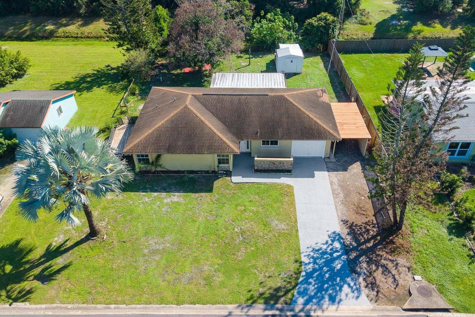 113 CONOVER Avenue, Sebastian, FL 32958 Single-story residence featuring a hip roof, attached garage, stone-accented exterior wall, and a wood-frame covered patio