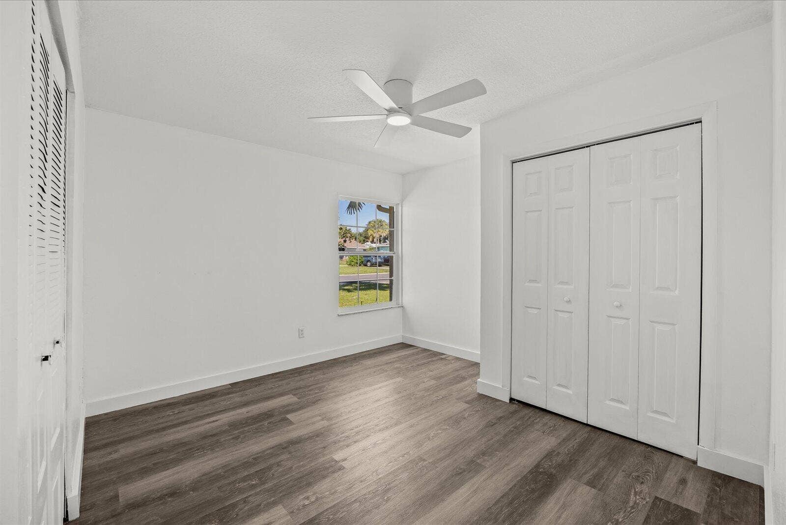 113 CONOVER Avenue, Sebastian, FL 32958 Interior room featuring wood-finish flooring, a ceiling fan with integrated lighting, a single window, and a white bifold closet door