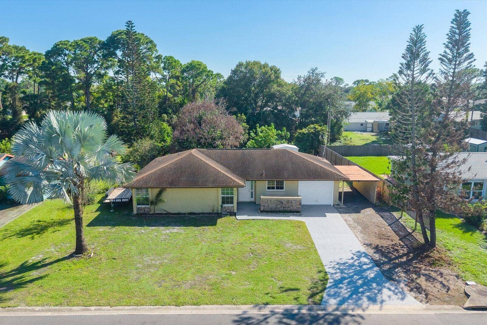 113 CONOVER Avenue, Sebastian, FL 32958 Single-story exterior featuring a hip roof, stone veneer accents, an attached carport, and a concrete driveway