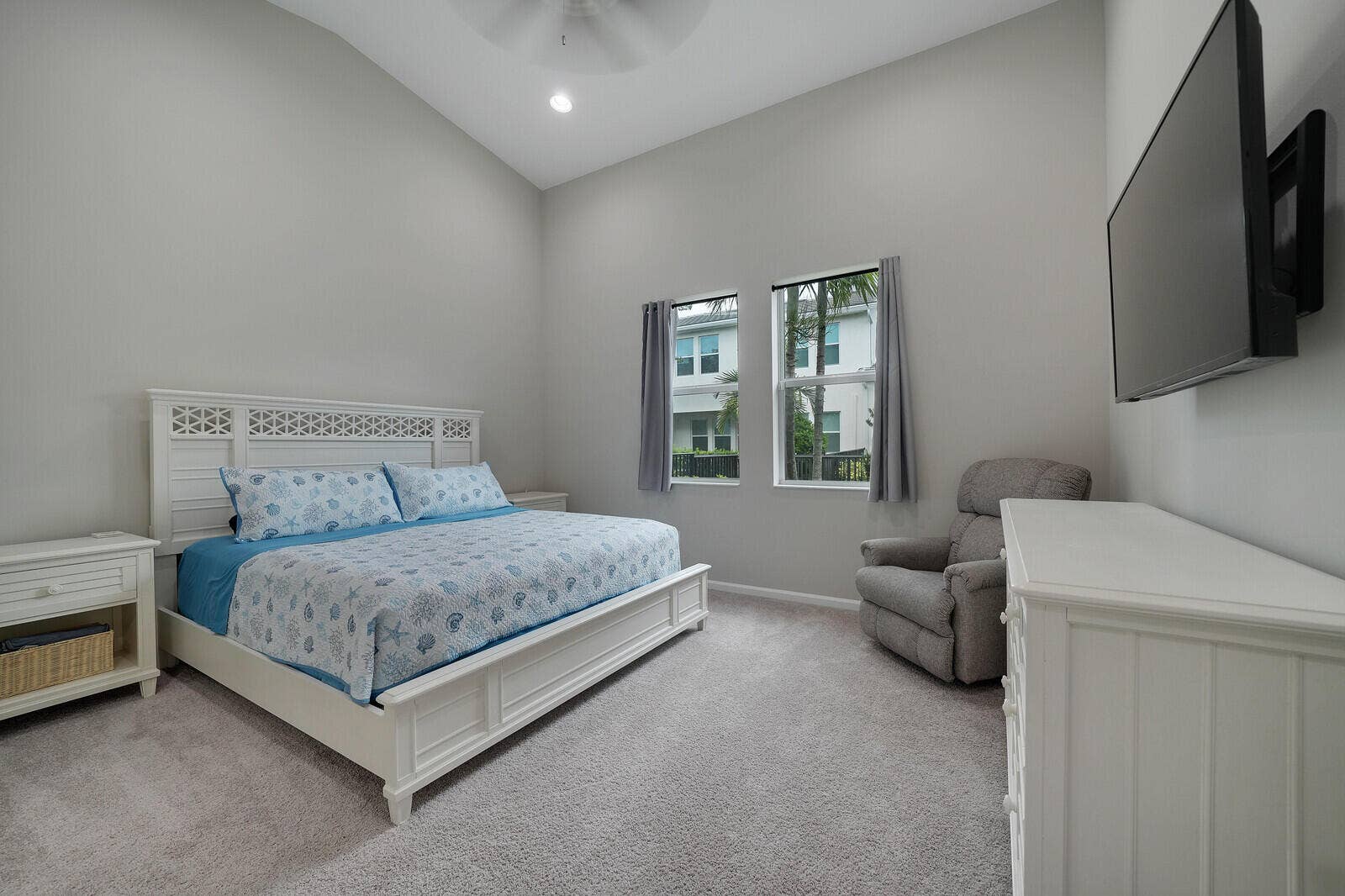 Large 1st Floor Convenient Primary Bedroom featuring Vaulted ceilings, carpeted flooring, dual-pane windows, and a ceiling-mounted light fixture.