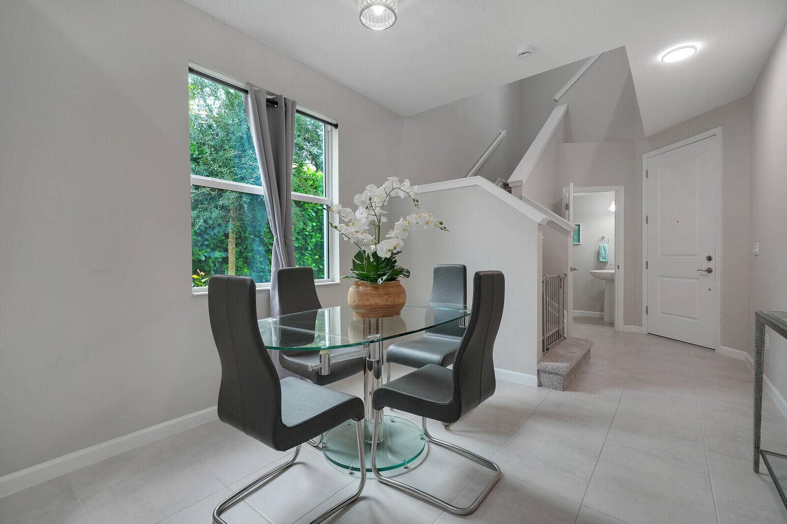 Neutral interior space featuring large window, recessed lighting, tile flooring, and a multi-panel door