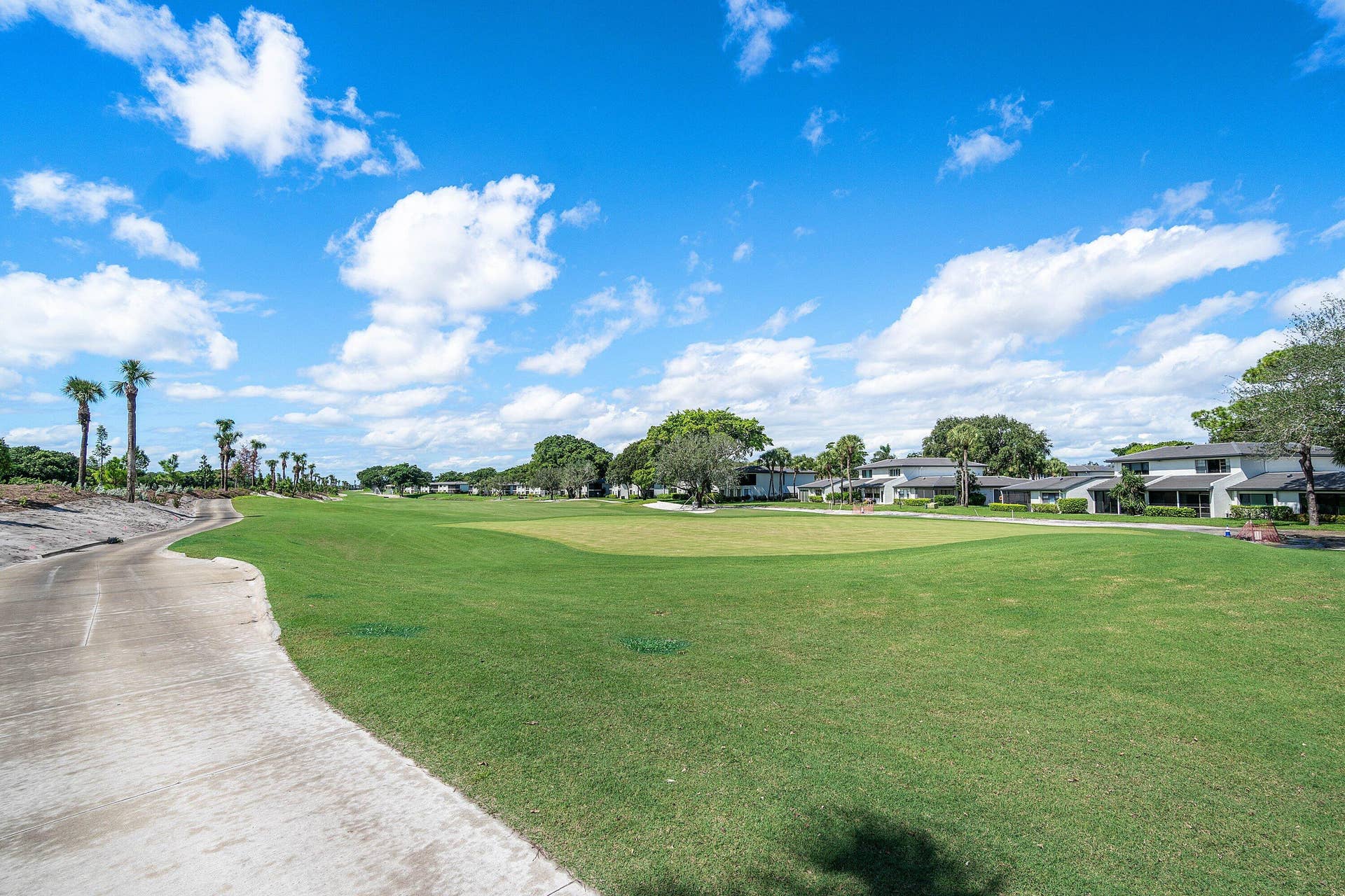 21 Southport Lane, #B, Boynton Beach, FL 33436 Expansive golf course grounds featuring a concrete cart path, manicured turf, mature trees, and landscaping