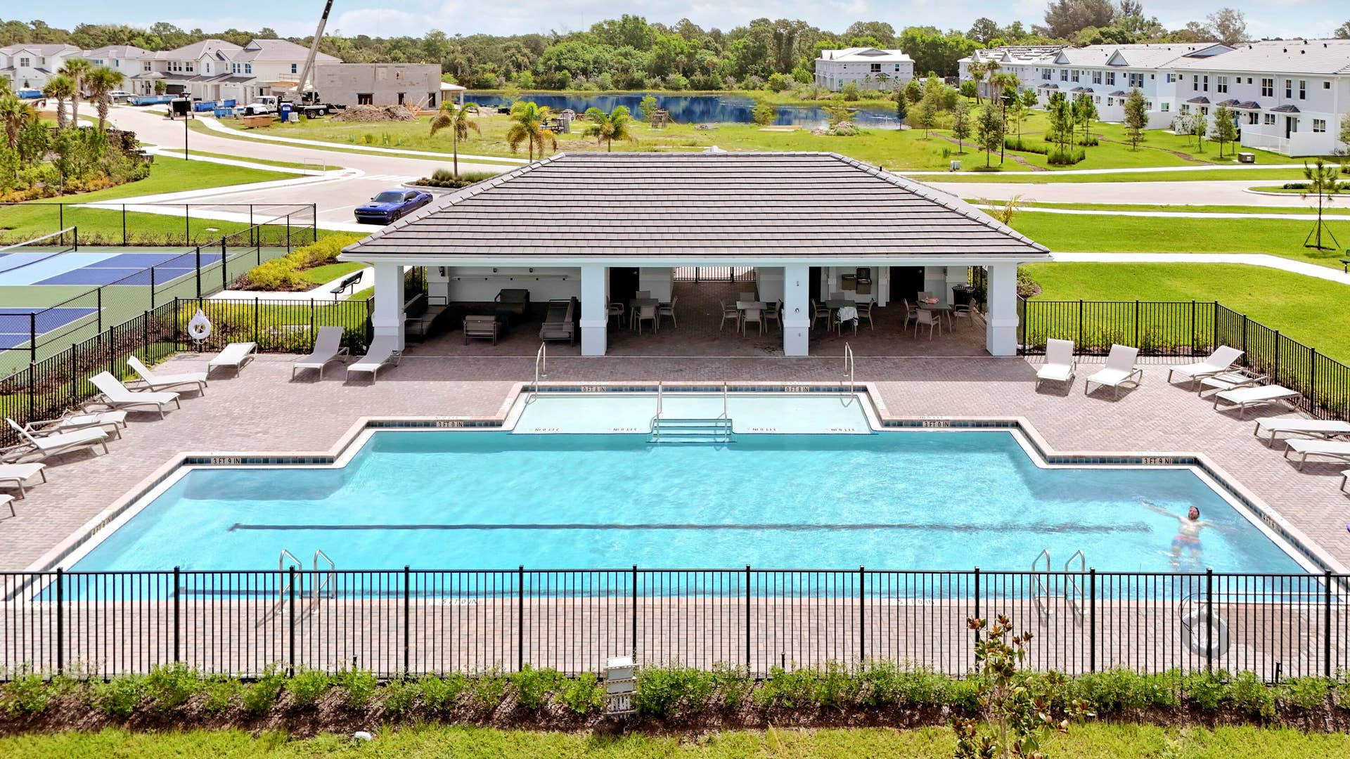 6742 SE LOST PINE Drive, Stuart, FL 34997 Community swimming pool with paver decking, covered pavilion, metal fencing, and pickleball court.