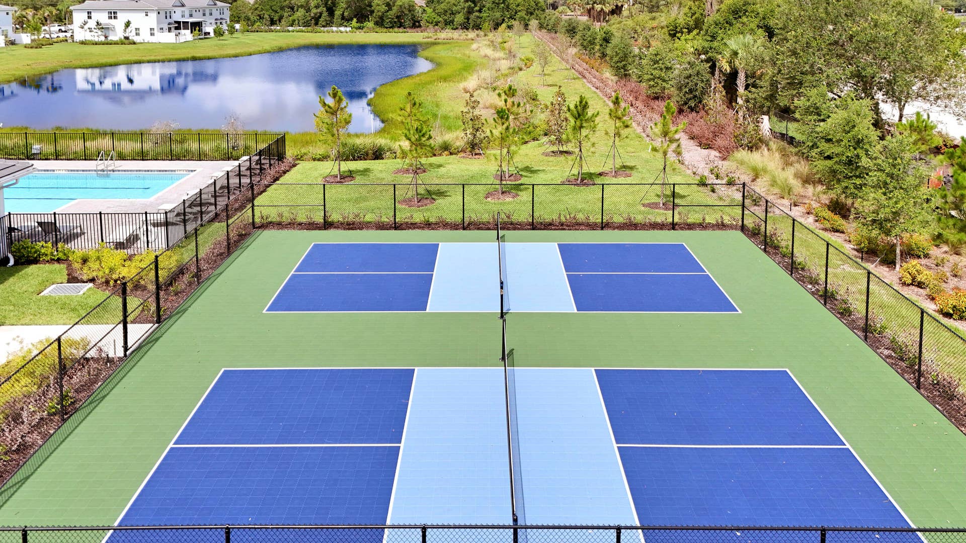 6742 SE LOST PINE Drive, Stuart, FL 34997 Multi-court athletic facility featuring blue and green surfaces, perimeter chain-link fencing, and an open-air layout.