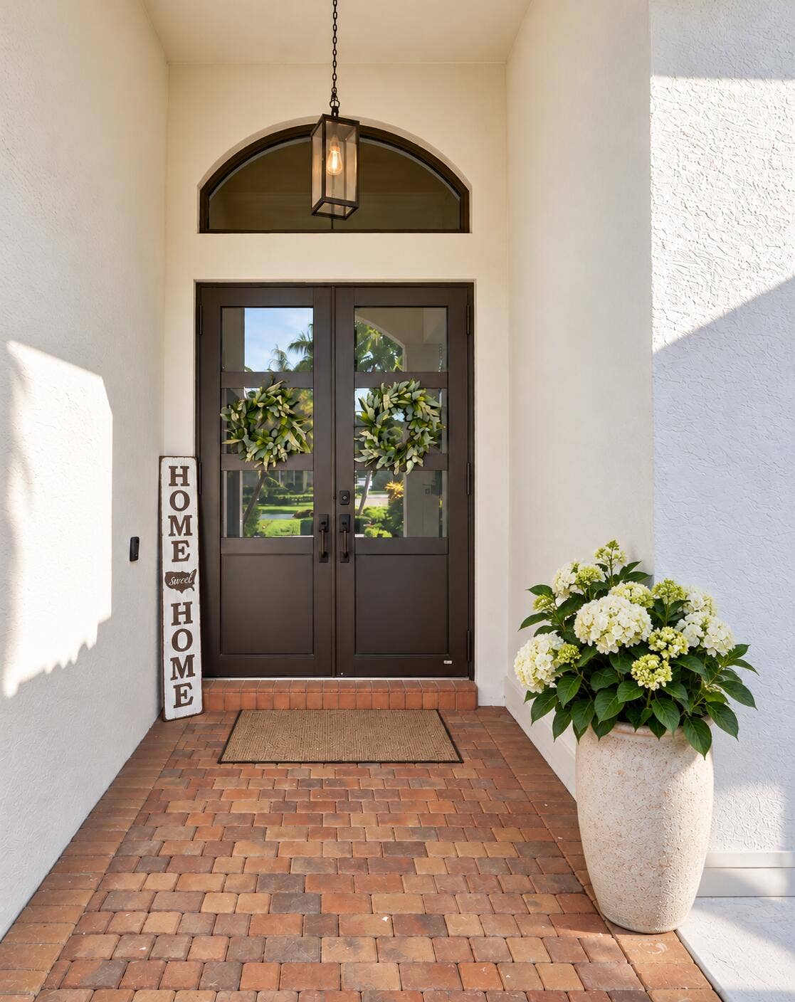 Inviting covered front door entry with modern impact glass doors
