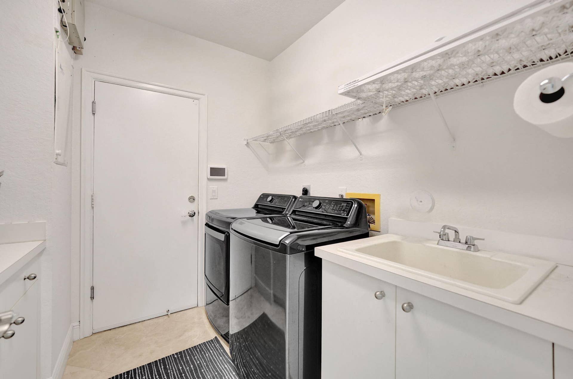Large laundry room with lots of cabinetry and sink