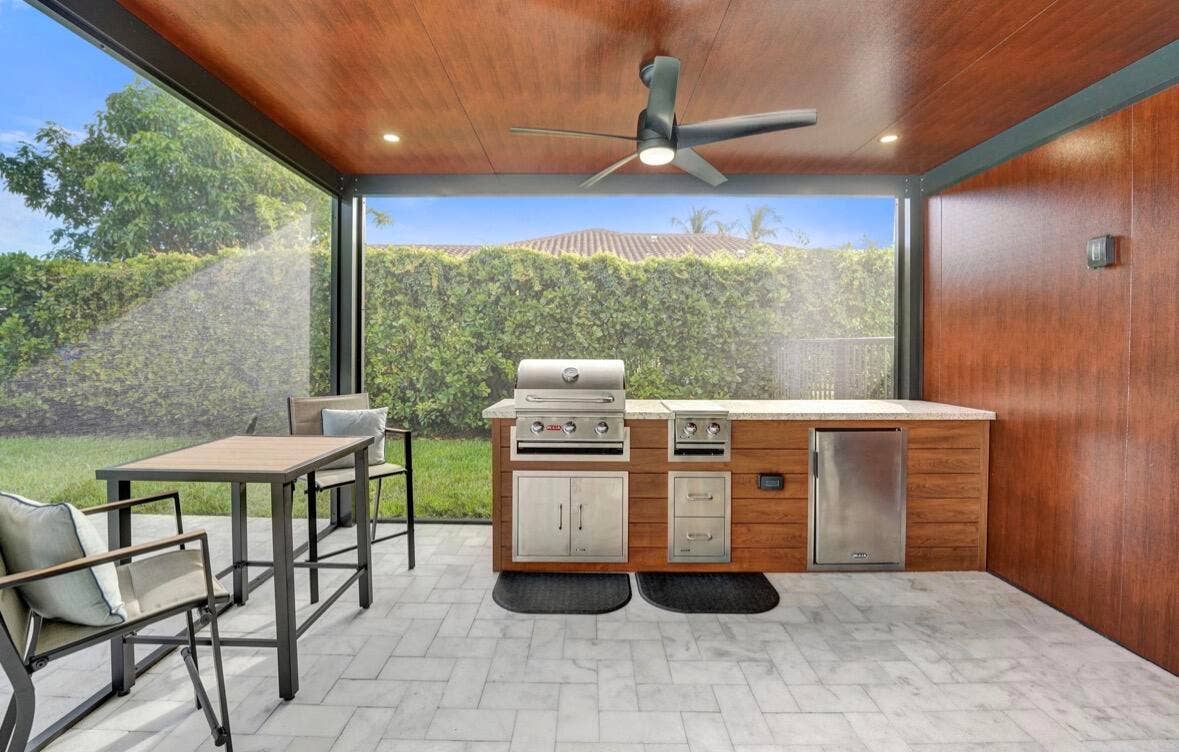 Extended covered patio with outdoor kitchen/BBQ grill/fridge.