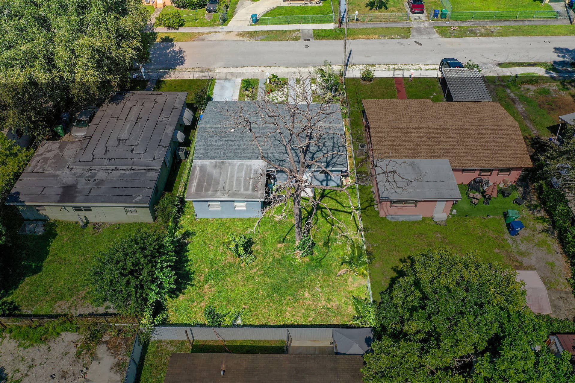 1946 NW 152nd Terrace, Miami Gardens, FL 33054 Aerial perspective of a property featuring a rectangular lot, shingle roofing, concrete driveway, and a rear perimeter fence