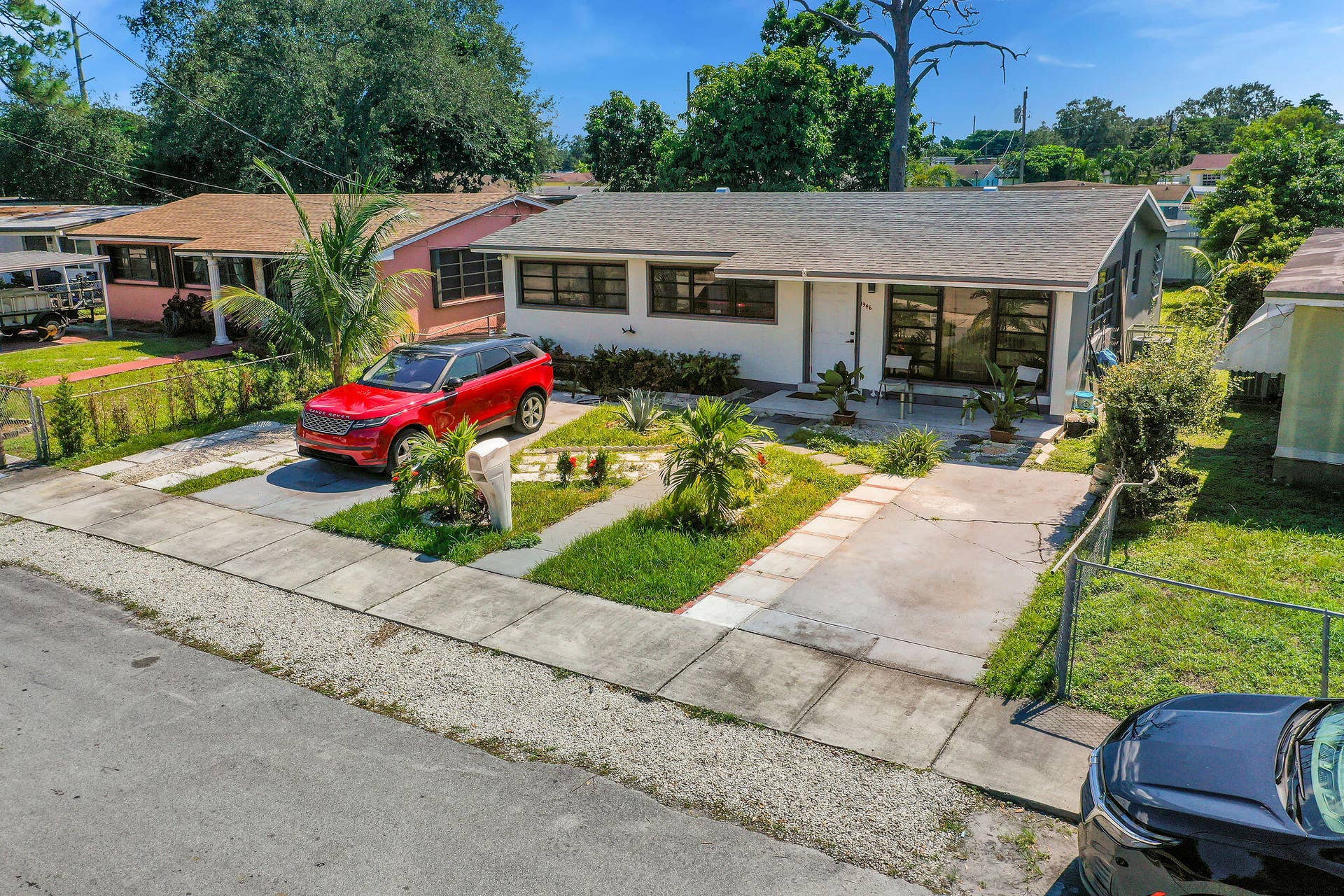 1946 NW 152nd Terrace, Miami Gardens, FL 33054 Single-story residence featuring a neutral exterior, multi-pane windows, asphalt shingle roof, concrete driveway, and a paved walkway