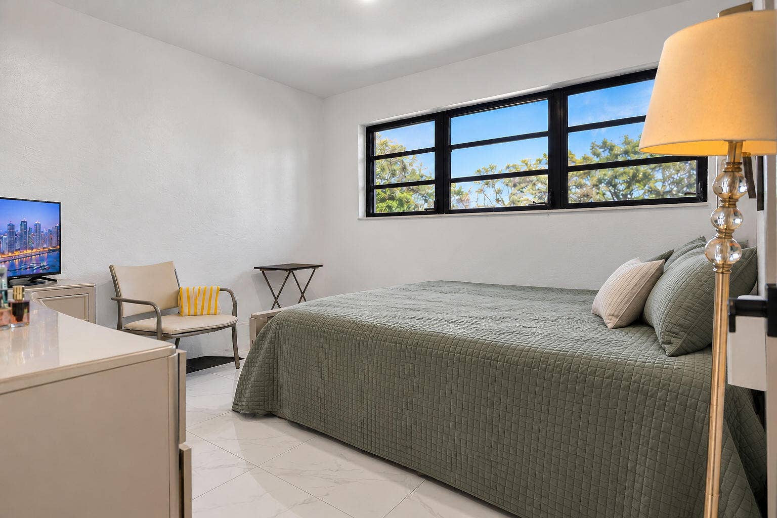 1946 NW 152nd Terrace, Miami Gardens, FL 33054 Neutral interior space featuring polished tile flooring, smooth wall finishes, and large horizontal-pane windows with black frames