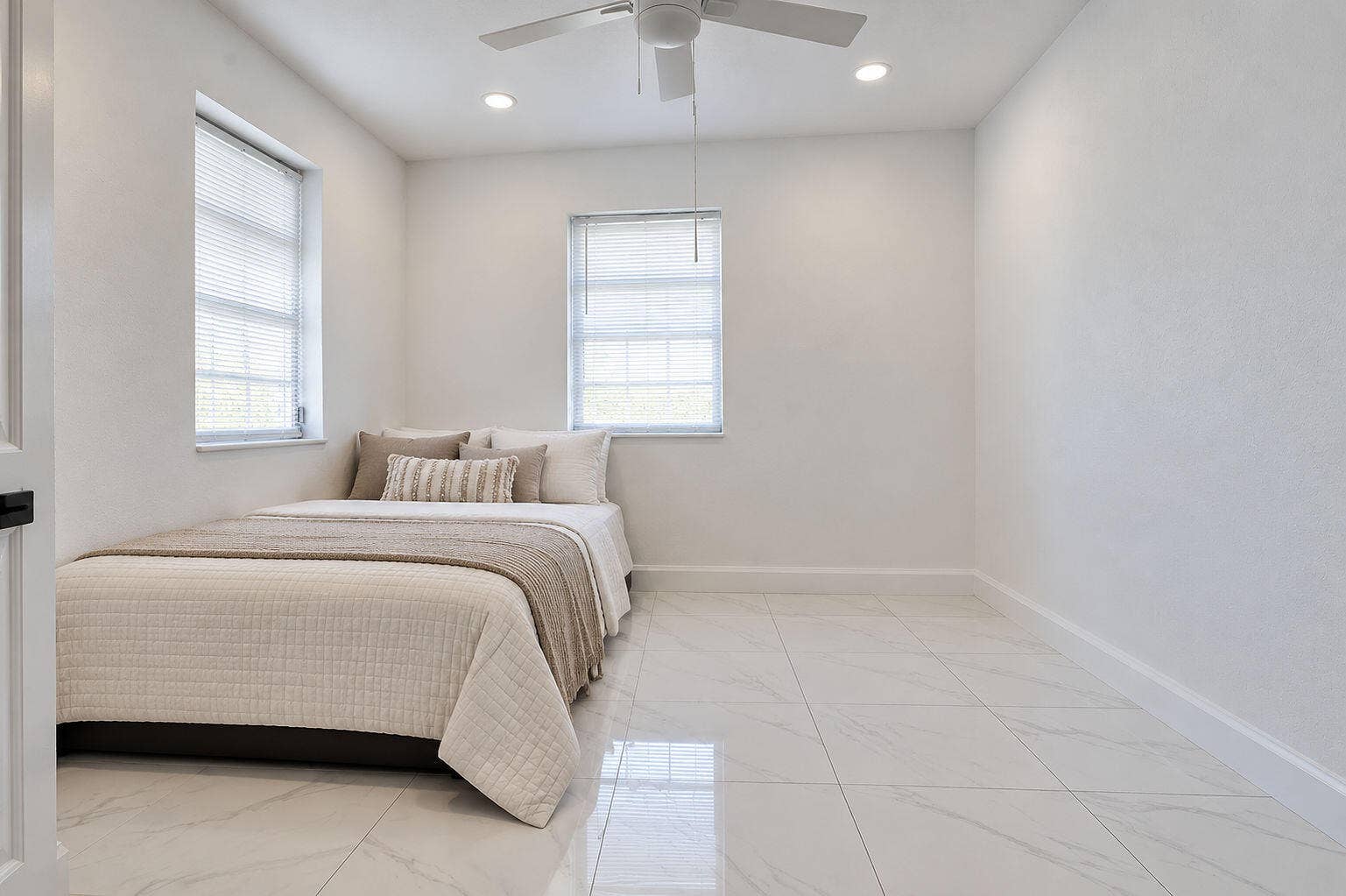 1946 NW 152nd Terrace, Miami Gardens, FL 33054 Neutral-toned interior featuring large-format tile flooring, recessed lighting, and a white ceiling fan with integrated light