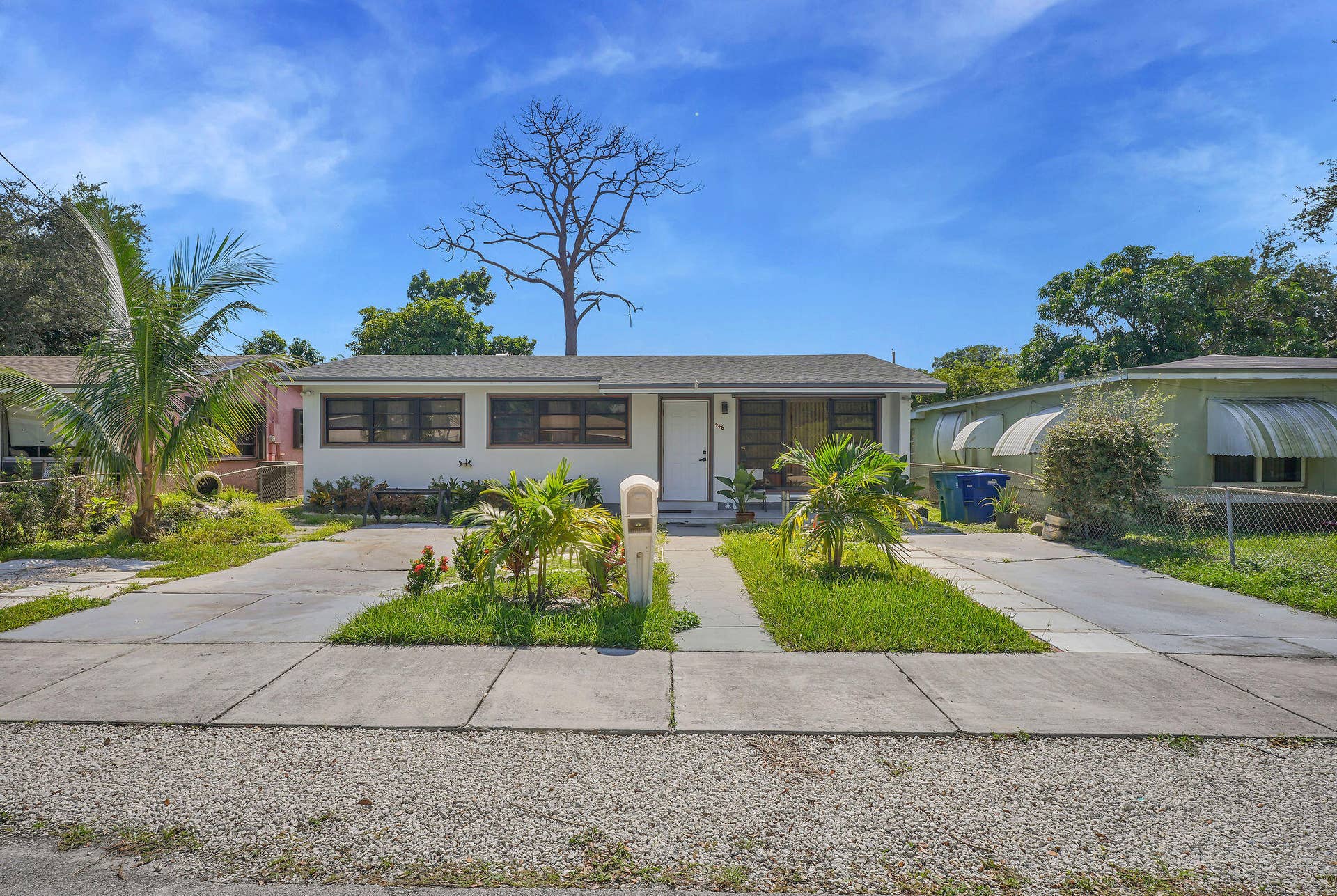 1946 NW 152nd Terrace, Miami Gardens, FL 33054 Single-story exterior featuring a light-colored facade, dual concrete driveways, and established tropical landscaping