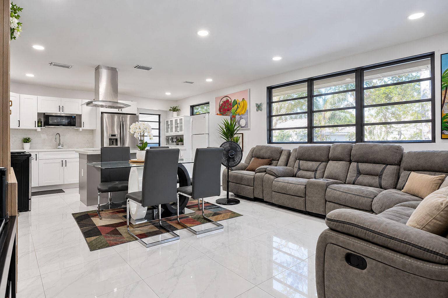 1946 NW 152nd Terrace, Miami Gardens, FL 33054 Open-concept space featuring polished tile flooring, recessed lighting, white shaker-style cabinetry, stainless steel range hood, and large picture windows