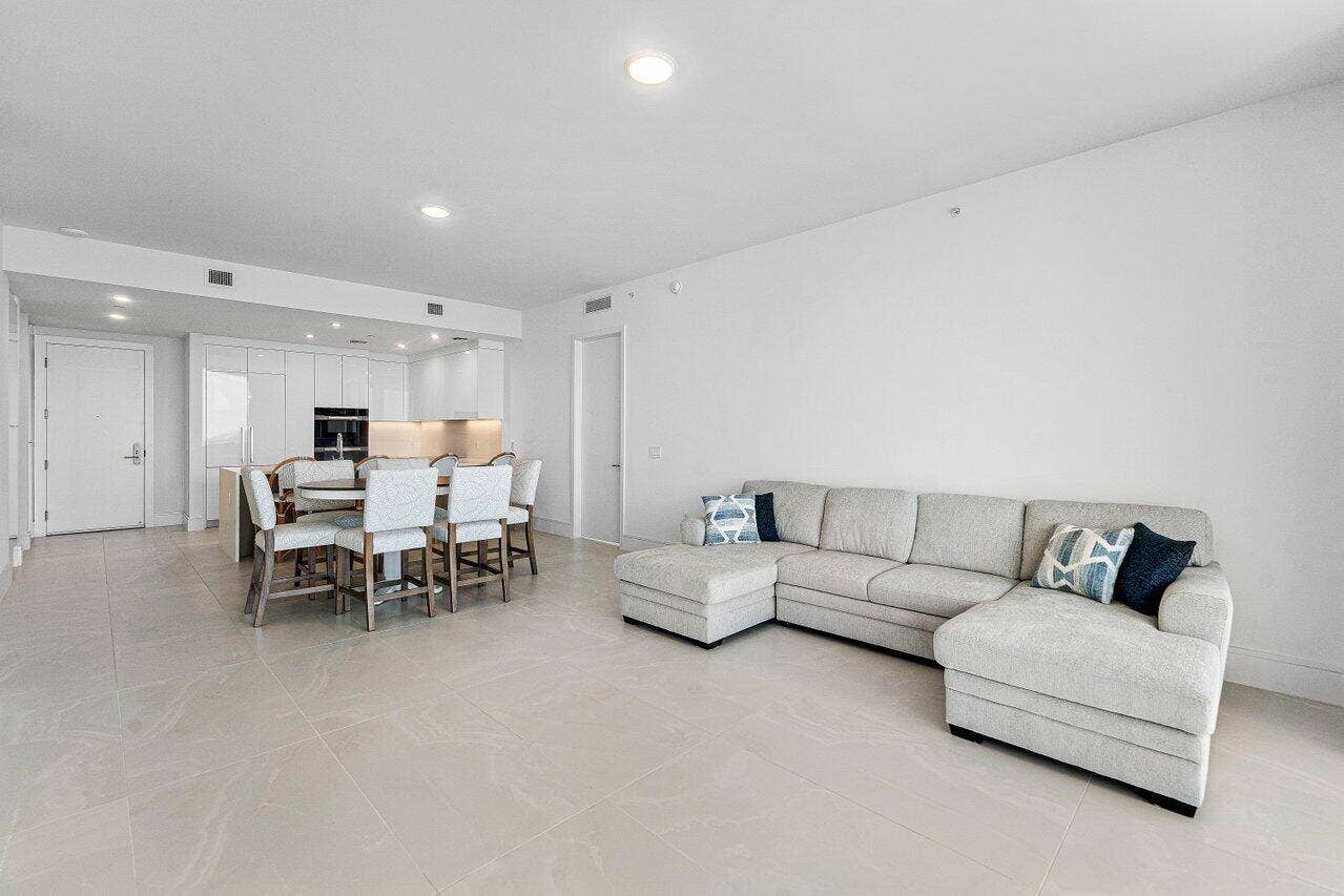 Open-concept interior featuring large-format tile flooring, recessed ceiling lighting, and minimalist flat-panel cabinetry