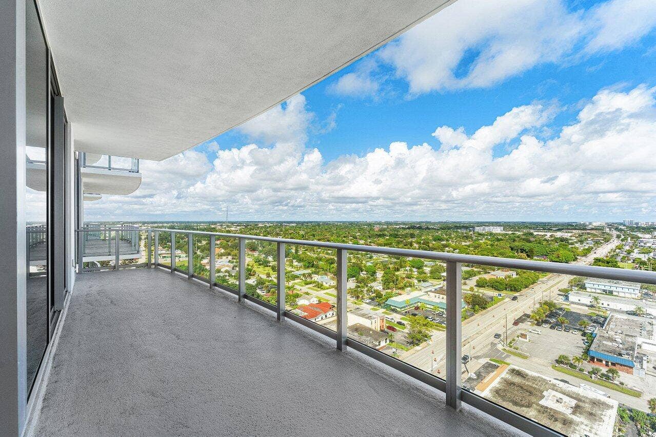 Private balcony featuring a concrete floor, glass and metal railing, and an overhead canopy