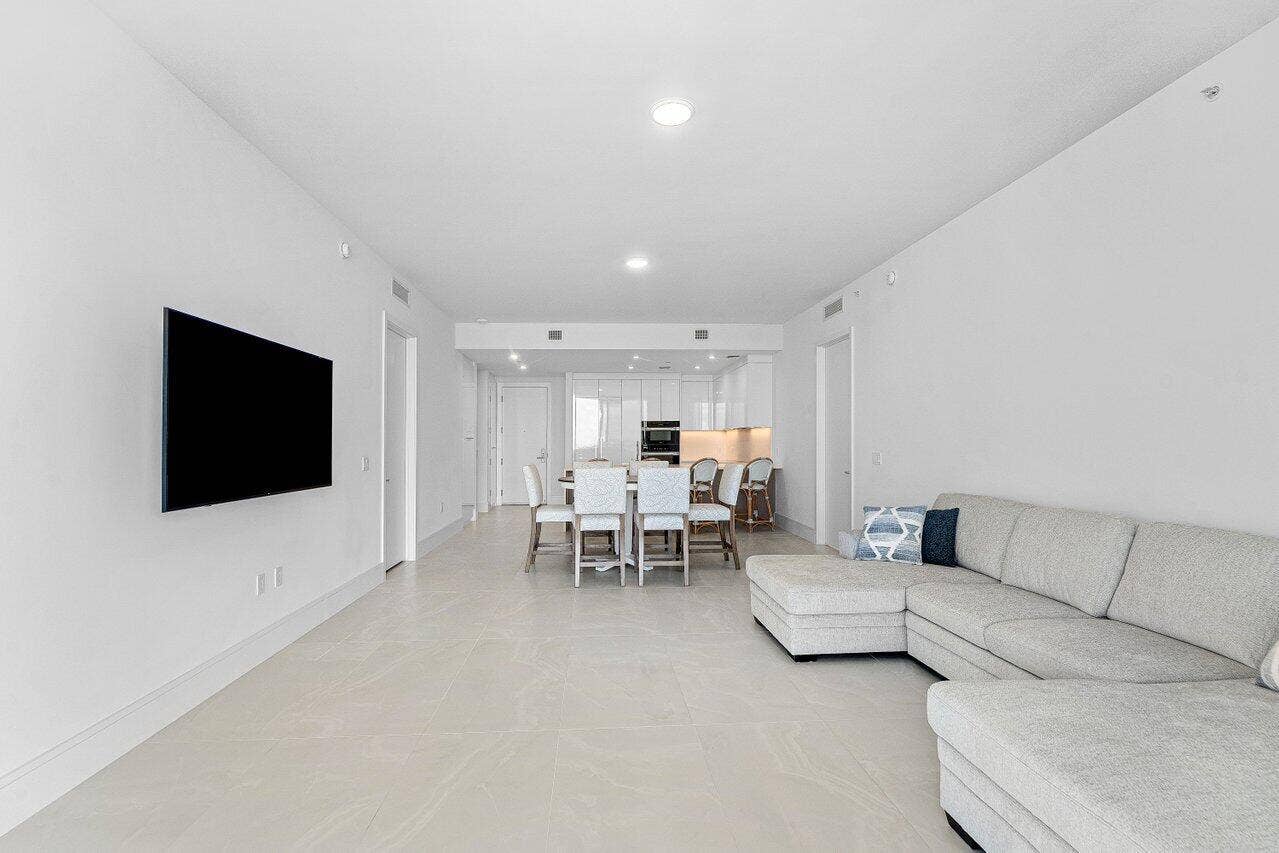Open-concept area featuring light-toned tile flooring, recessed ceiling lighting, and crisp white walls