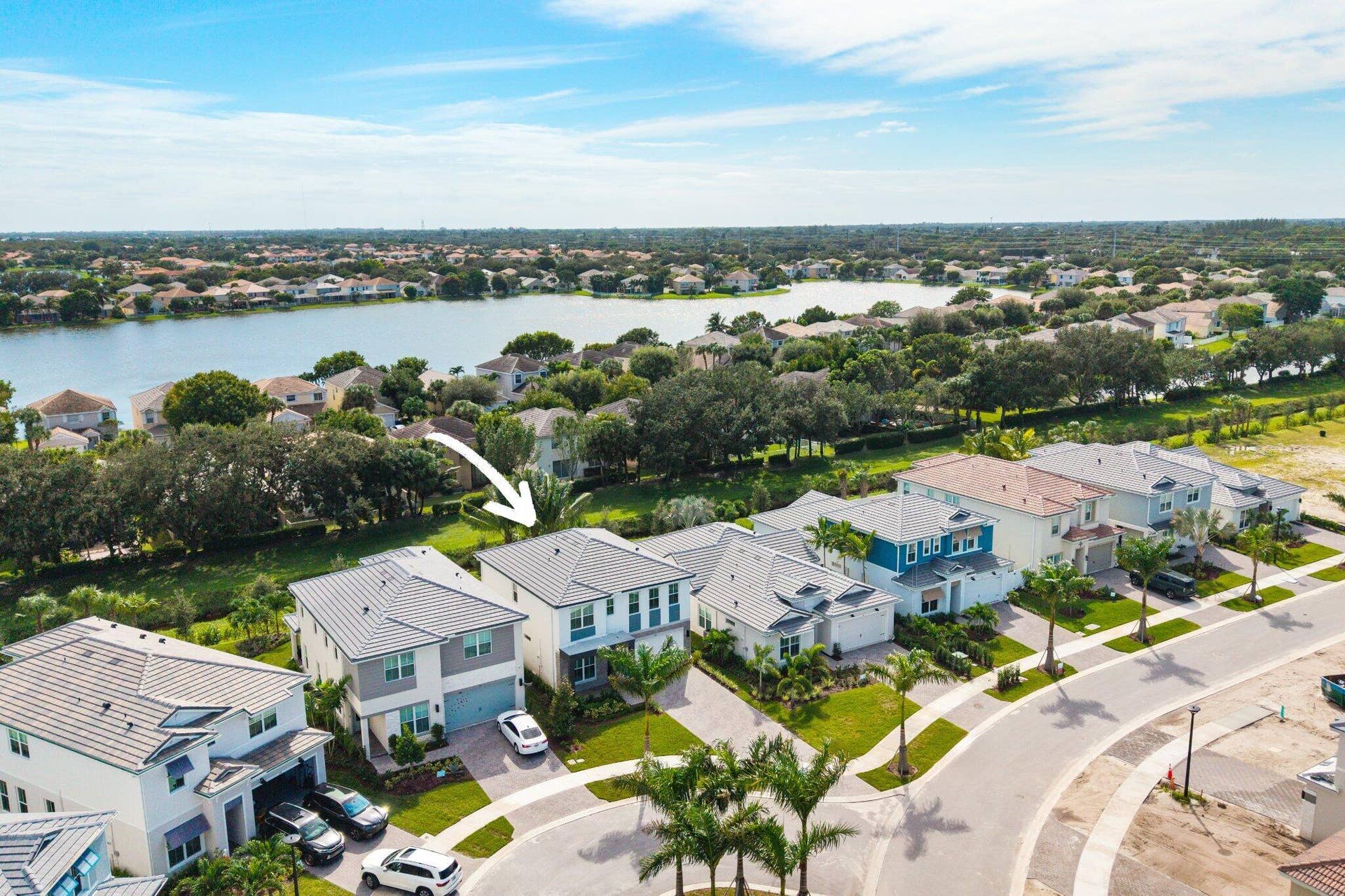 Two-story residence featuring a tile roof, paved driveway, two-car garage, and exterior masonry construction