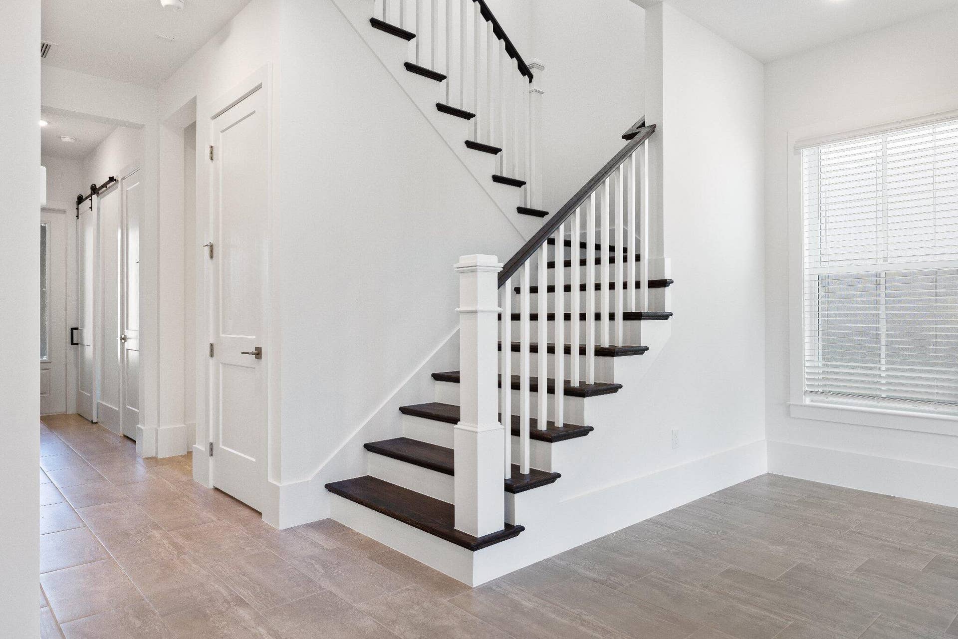Staircase featuring dark wood-finish treads, white balusters, and a square newel post