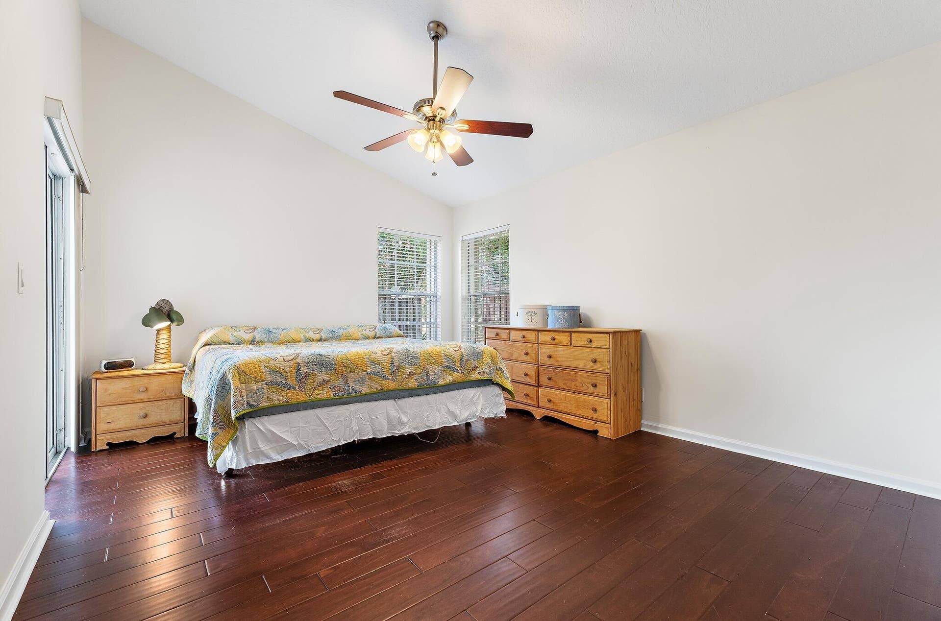 6037 Foster Street, Jupiter, FL 33458 Primary bedroom with wood floors and a ceiling fan.