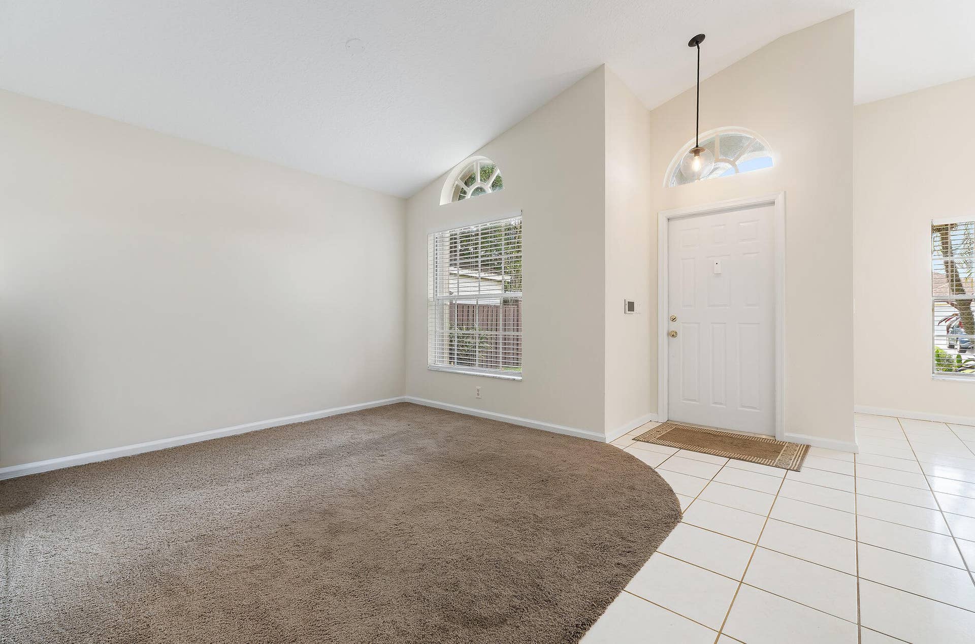 6037 Foster Street, Jupiter, FL 33458 Living room off the front entry, with high ceilings and an arched window.