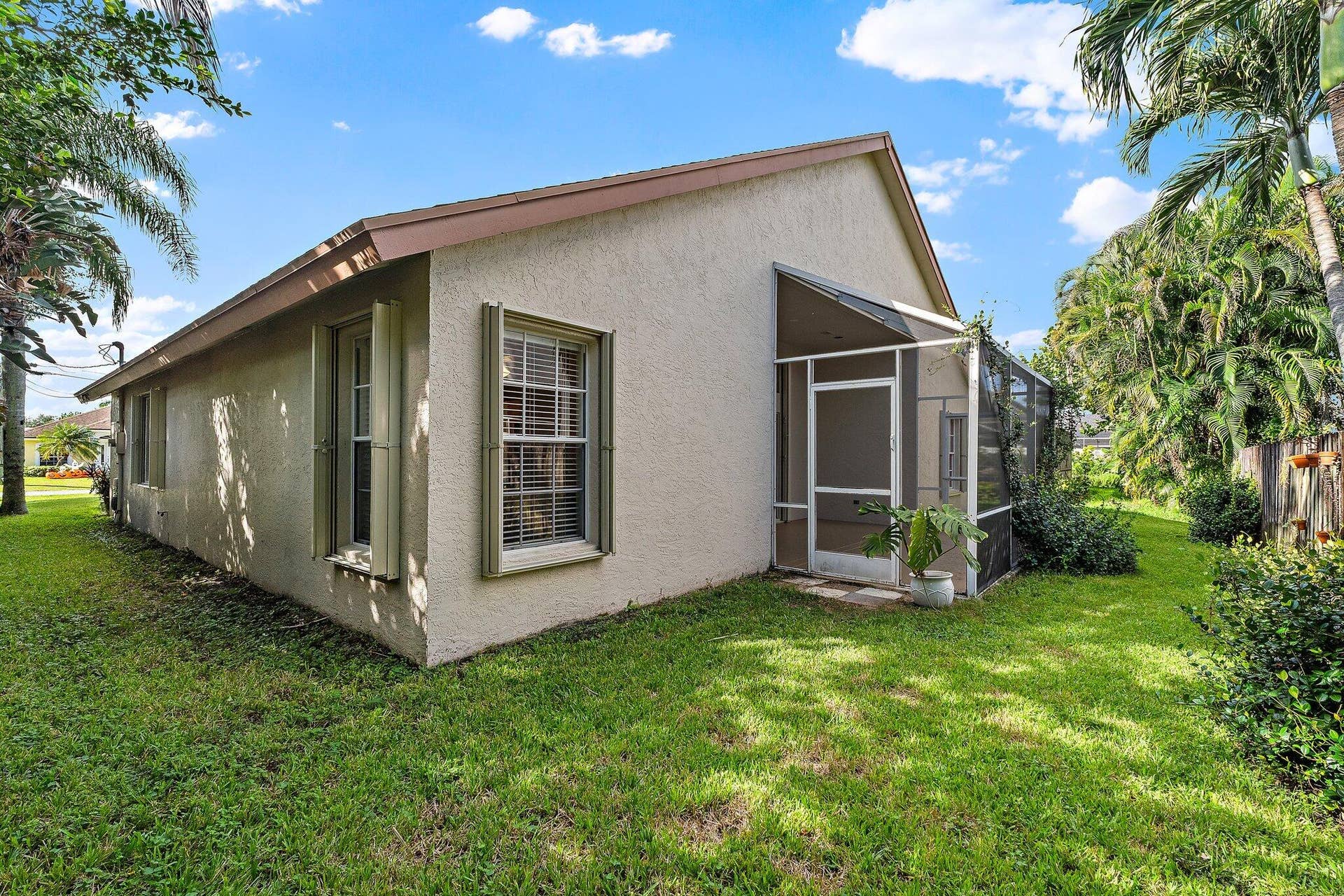 6037 Foster Street, Jupiter, FL 33458 Side of the home and backyard with mature palms.