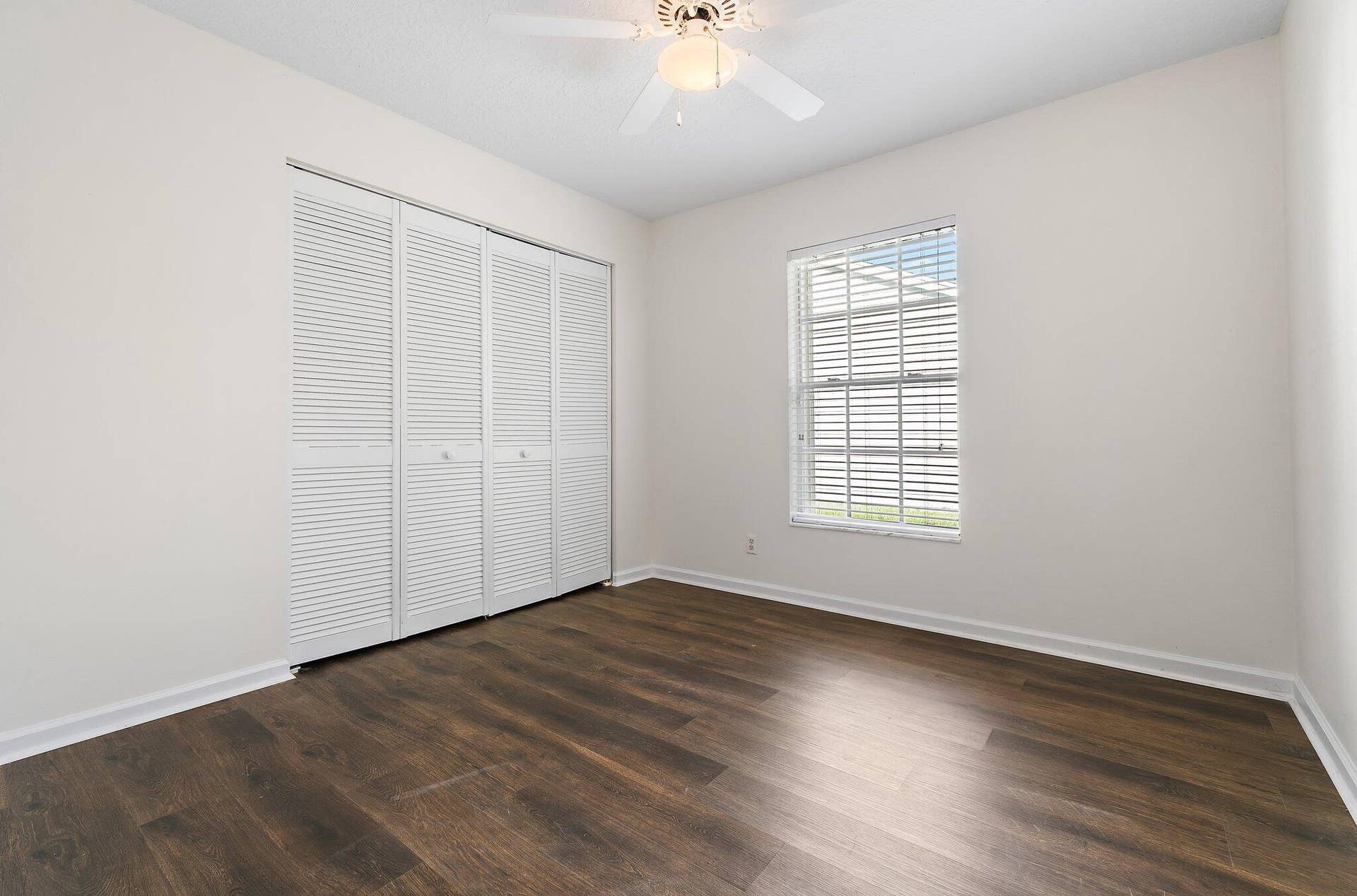 6037 Foster Street, Jupiter, FL 33458 Guest bedroom with wood-look floors and a double closet.