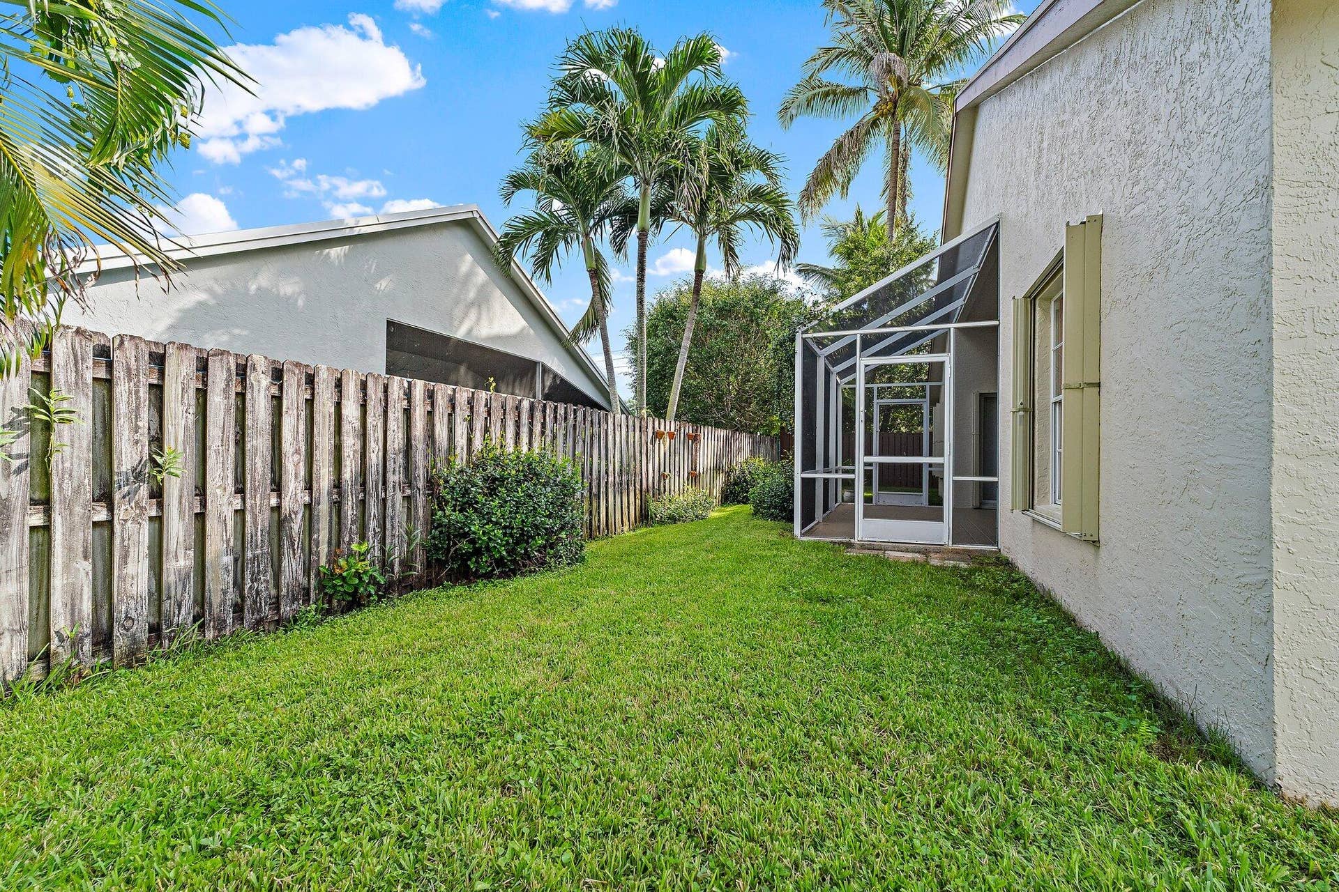 6037 Foster Street, Jupiter, FL 33458 Fenced side yard with tropical landscaping.