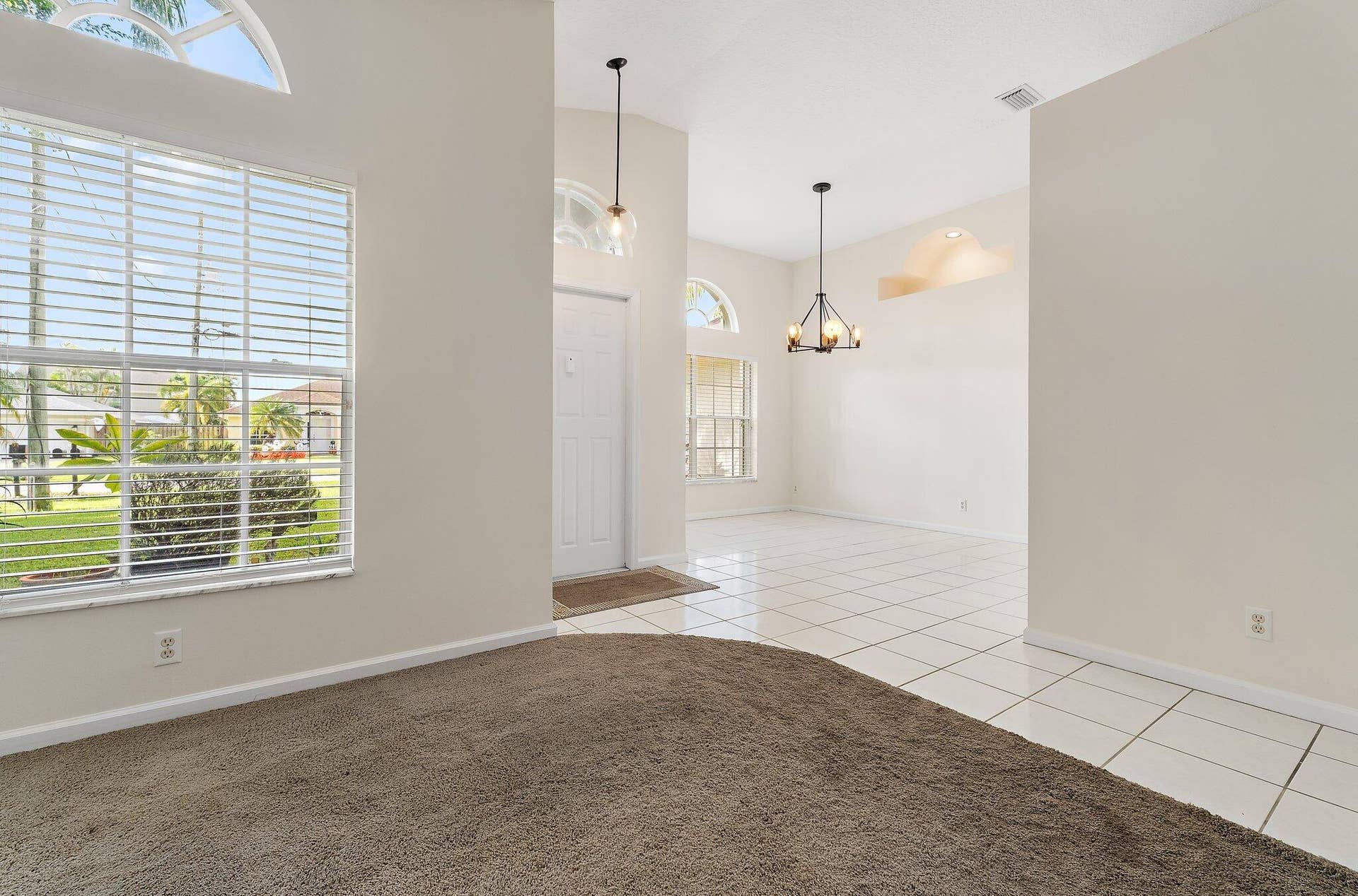 6037 Foster Street, Jupiter, FL 33458 Living room with high ceilings, open to the dining area.