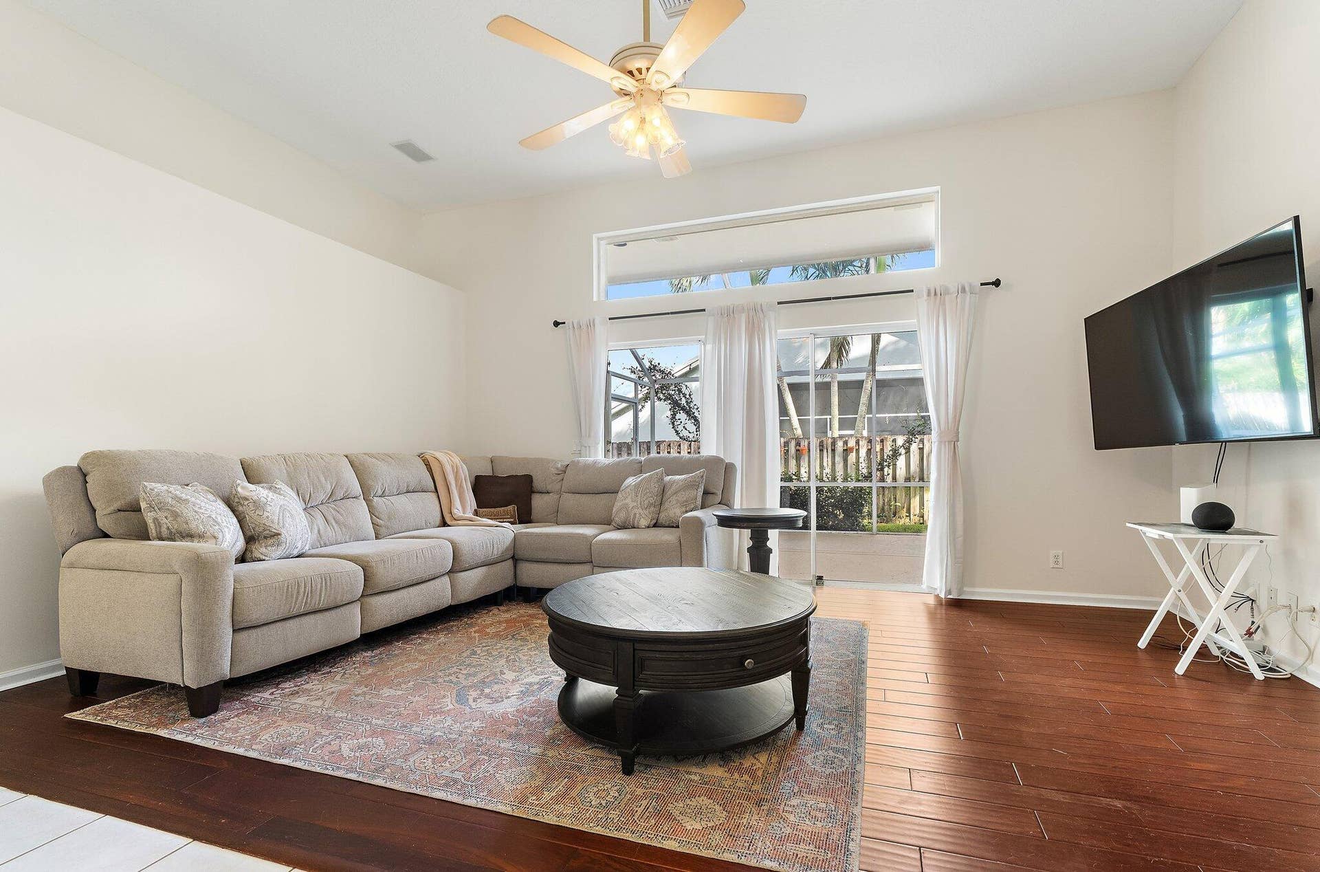 6037 Foster Street, Jupiter, FL 33458 Family room with wood floors and glass doors to the screened patio.