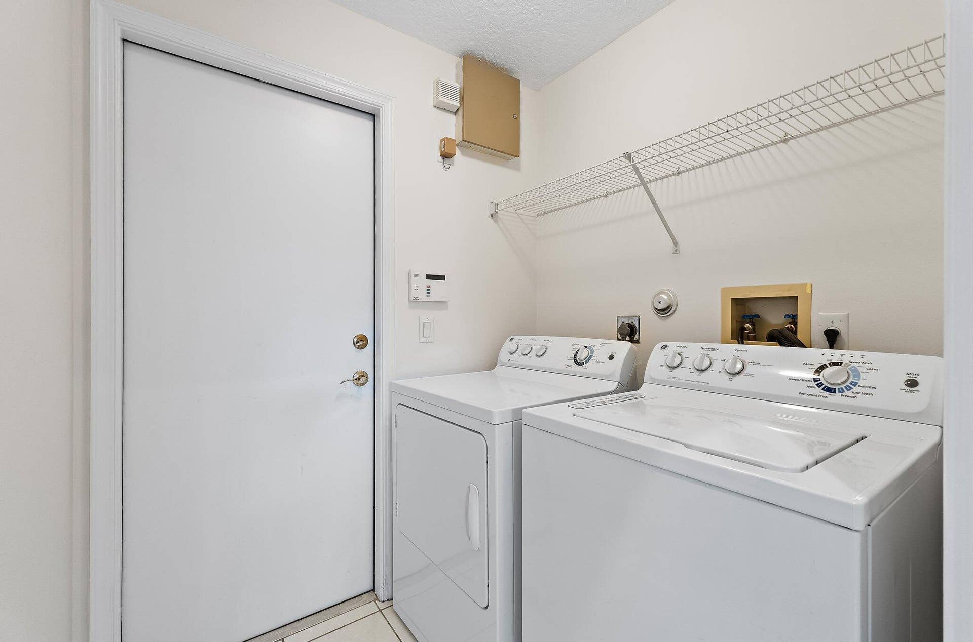 6037 Foster Street, Jupiter, FL 33458 Laundry room with washer, dryer and shelving.