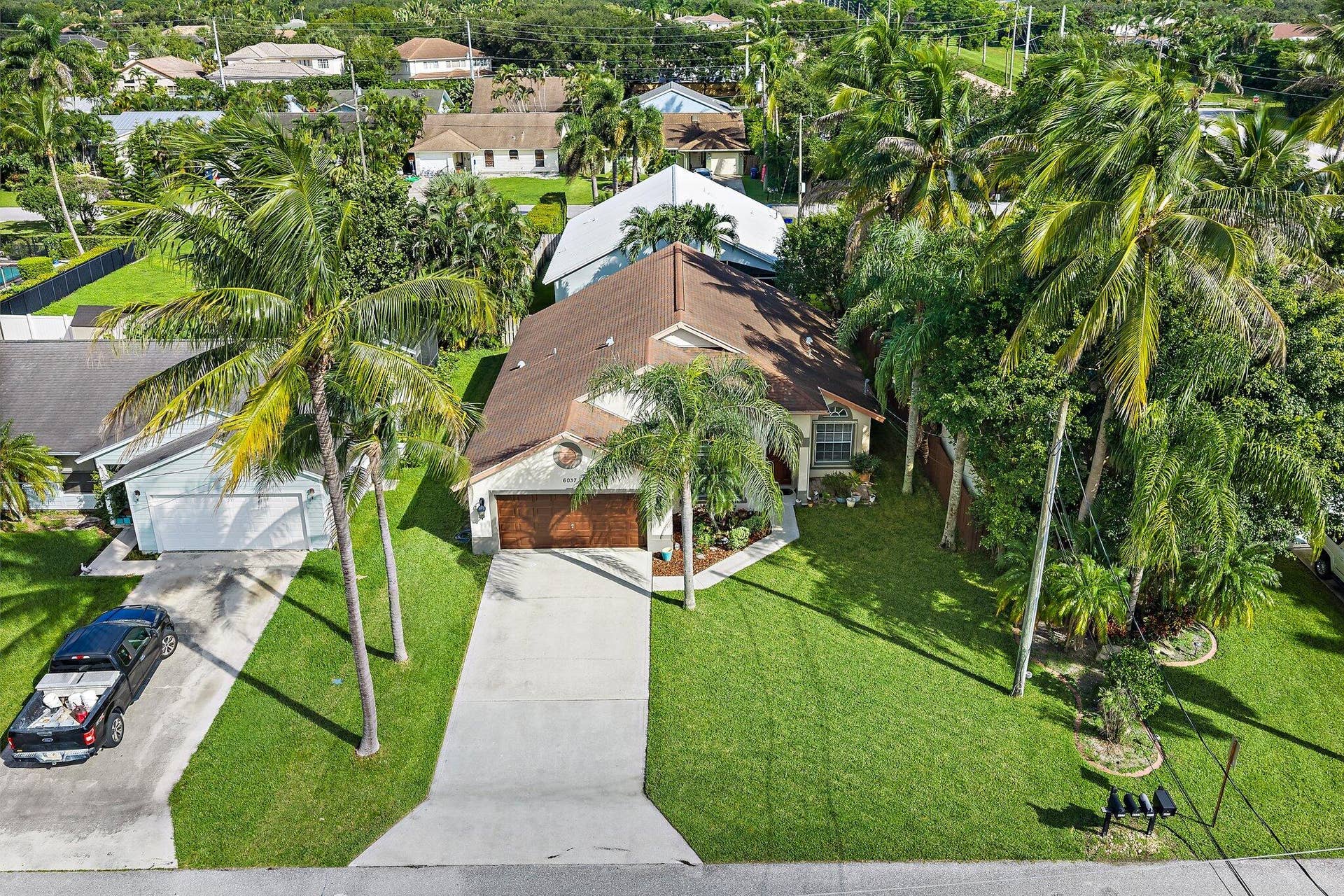 6037 Foster Street, Jupiter, FL 33458 Aerial view of the front of the home and driveway.