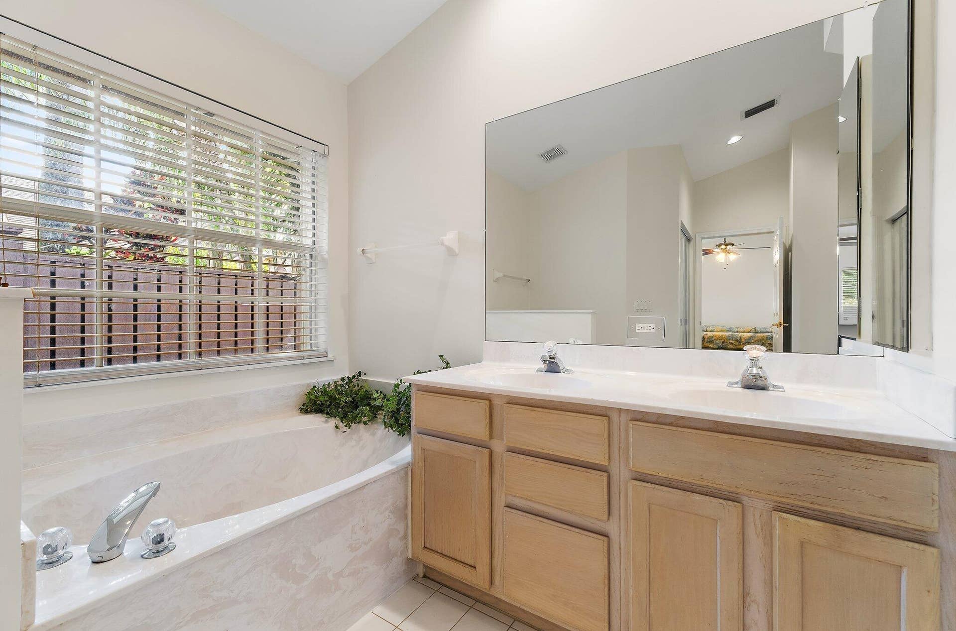 6037 Foster Street, Jupiter, FL 33458 Primary bath with a long vanity and soaking tub.
