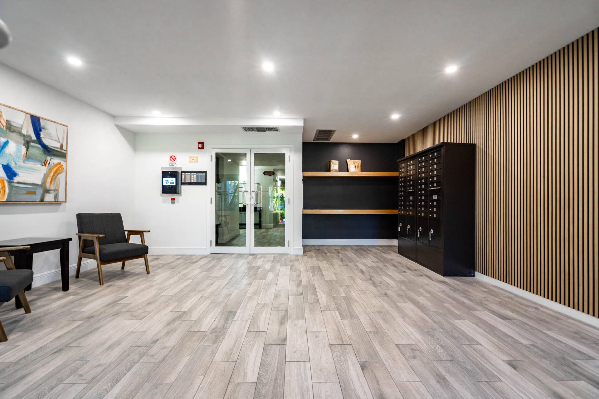 250 NE 20TH Street, #5260, Boca Raton, FL 33431 Lobby featuring wood-slat accent wall, tile flooring with wood finish, recessed lighting, built-in wall-mounted shelving, and integrated mailboxes