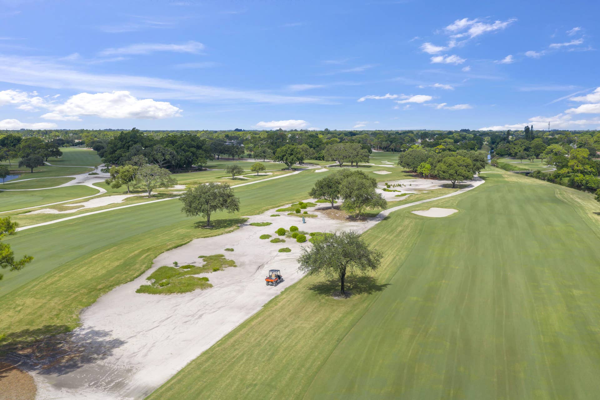 137 Clubhouse Boulevard, Atlantis, FL 33462 Aerial perspective of a golf course featuring expansive fairways, sand bunkers, mature trees, and manicured greens