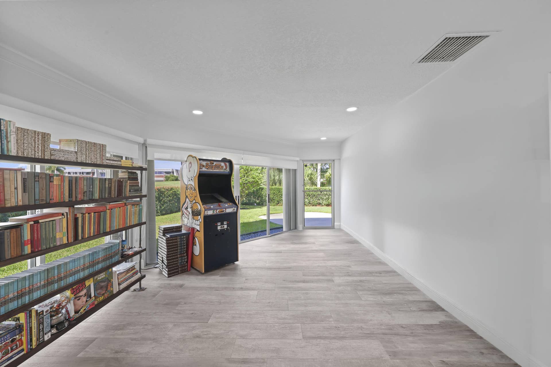 137 Clubhouse Boulevard, Atlantis, FL 33462 Spacious interior featuring wood-finish flooring, recessed lighting, and expansive glass sliding doors providing natural light