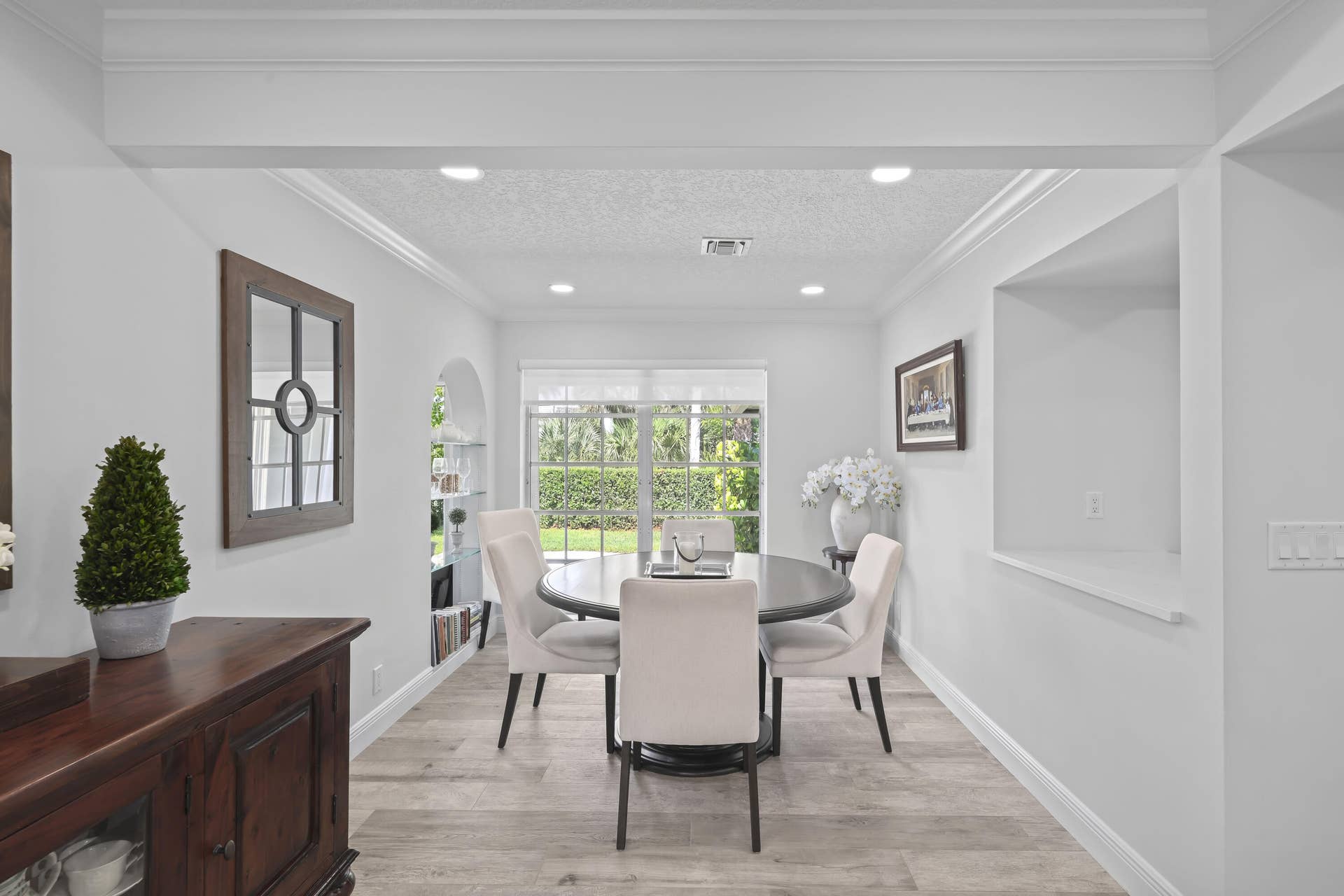 137 Clubhouse Boulevard, Atlantis, FL 33462 Interior space featuring wood-finish flooring, recessed lighting, crown molding, a built-in arched display niche, and a pass-through opening