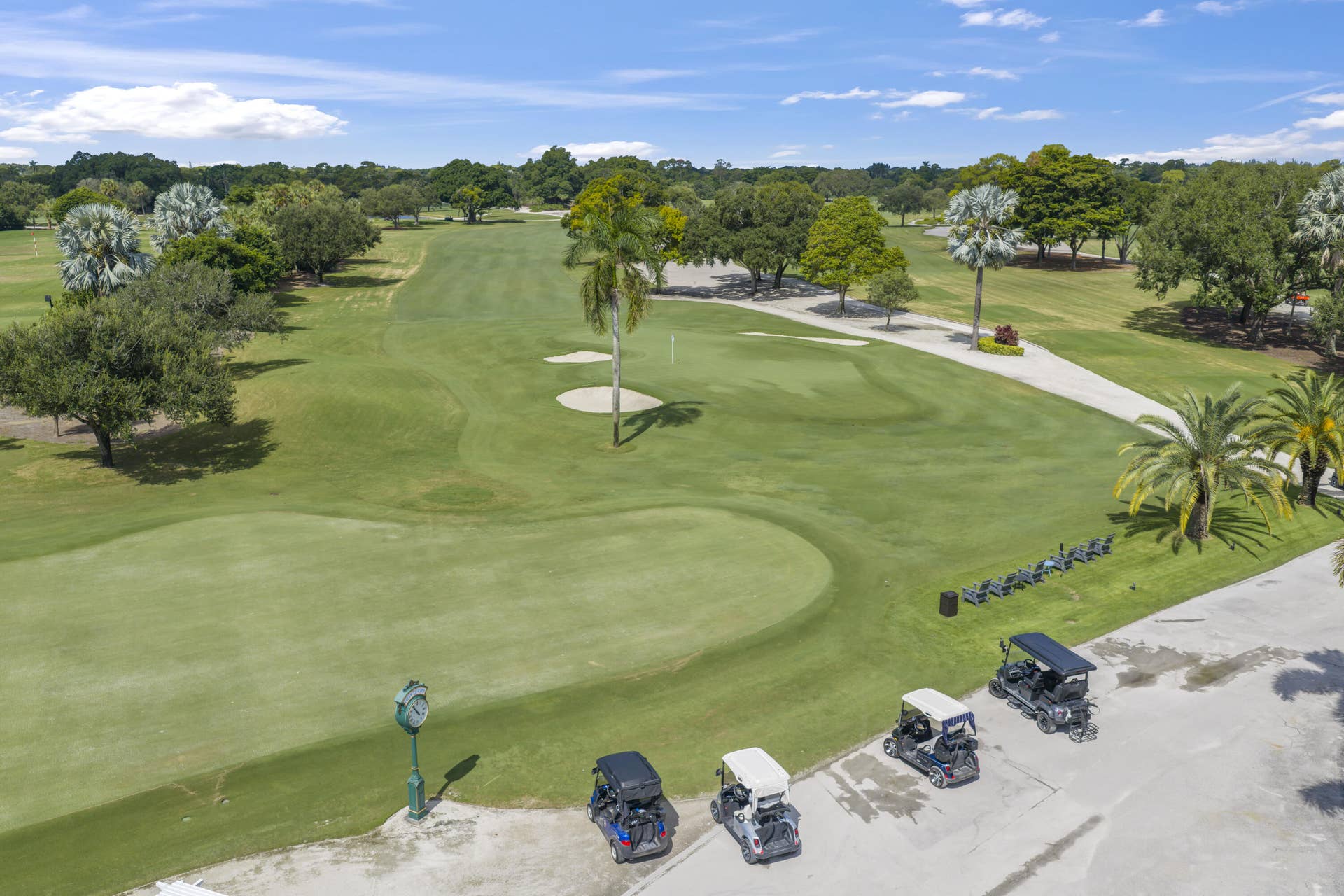 137 Clubhouse Boulevard, Atlantis, FL 33462 Expansive golf course grounds featuring manicured fairways, sand bunkers, mature trees, and palm landscaping