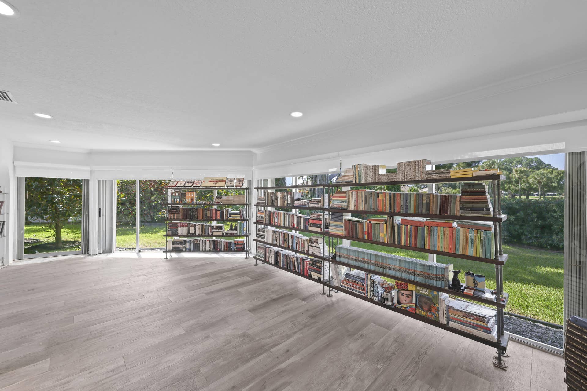 137 Clubhouse Boulevard, Atlantis, FL 33462 Light-filled room featuring wood-finish flooring, recessed lighting, and extensive floor-to-ceiling glass wall panels
